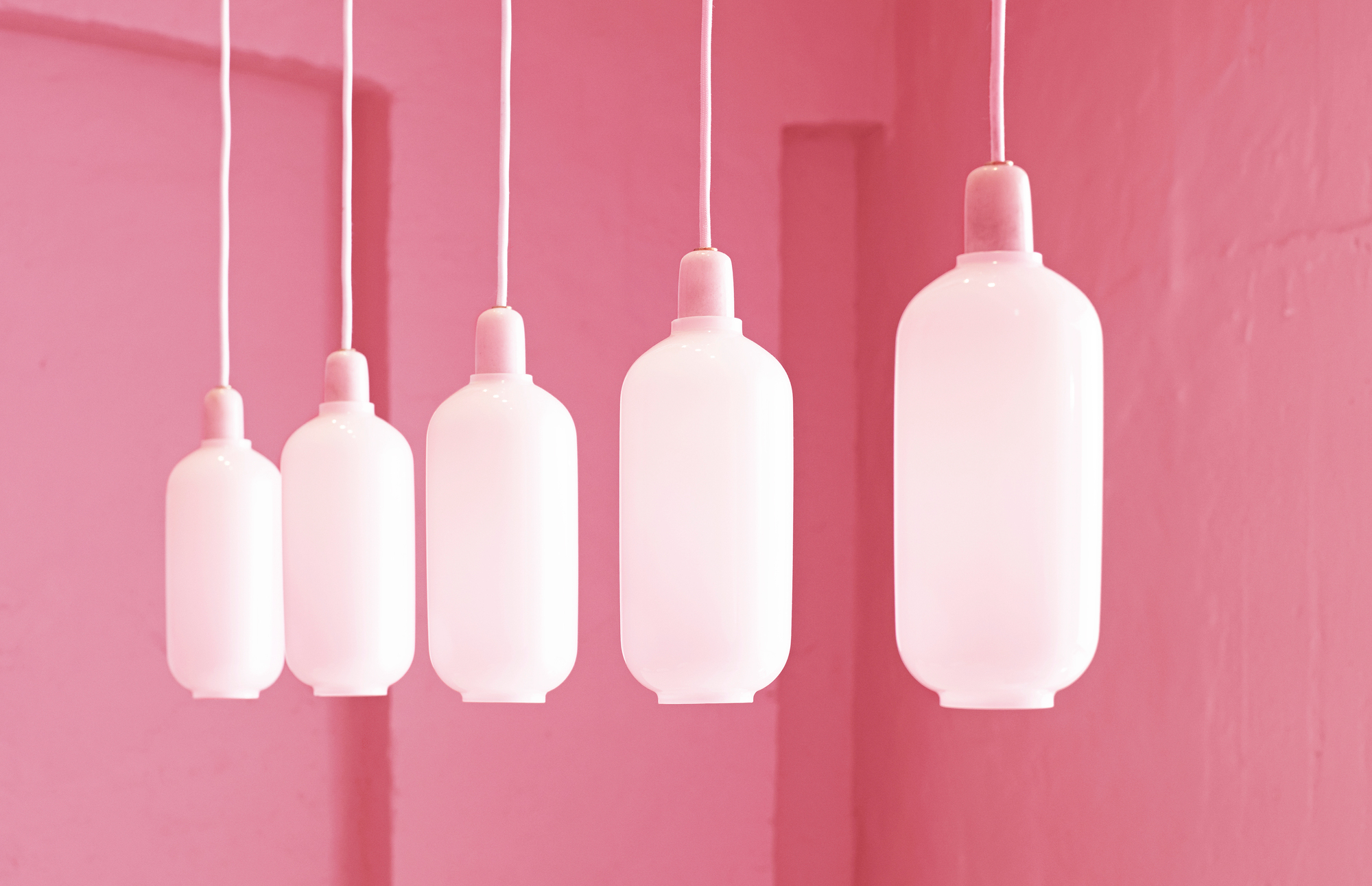 Nahaufnahme der Amp Lamp Hängeleuchte von Normann Copenhagen in Gold und Grün.