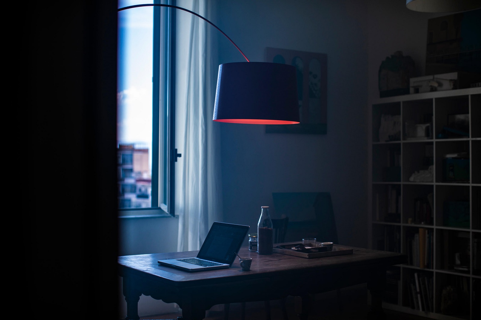 Twice as Twiggy Stehleuchte in Grau über einem Schreibtisch mit Laptop und Getränken im Wohnzimmer.