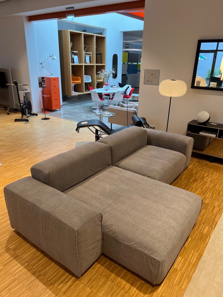 Graues Seatlife Sofa im modernen Wohnzimmer. Bequemes Ecksofa mit Ottomane und minimalistischem Design.