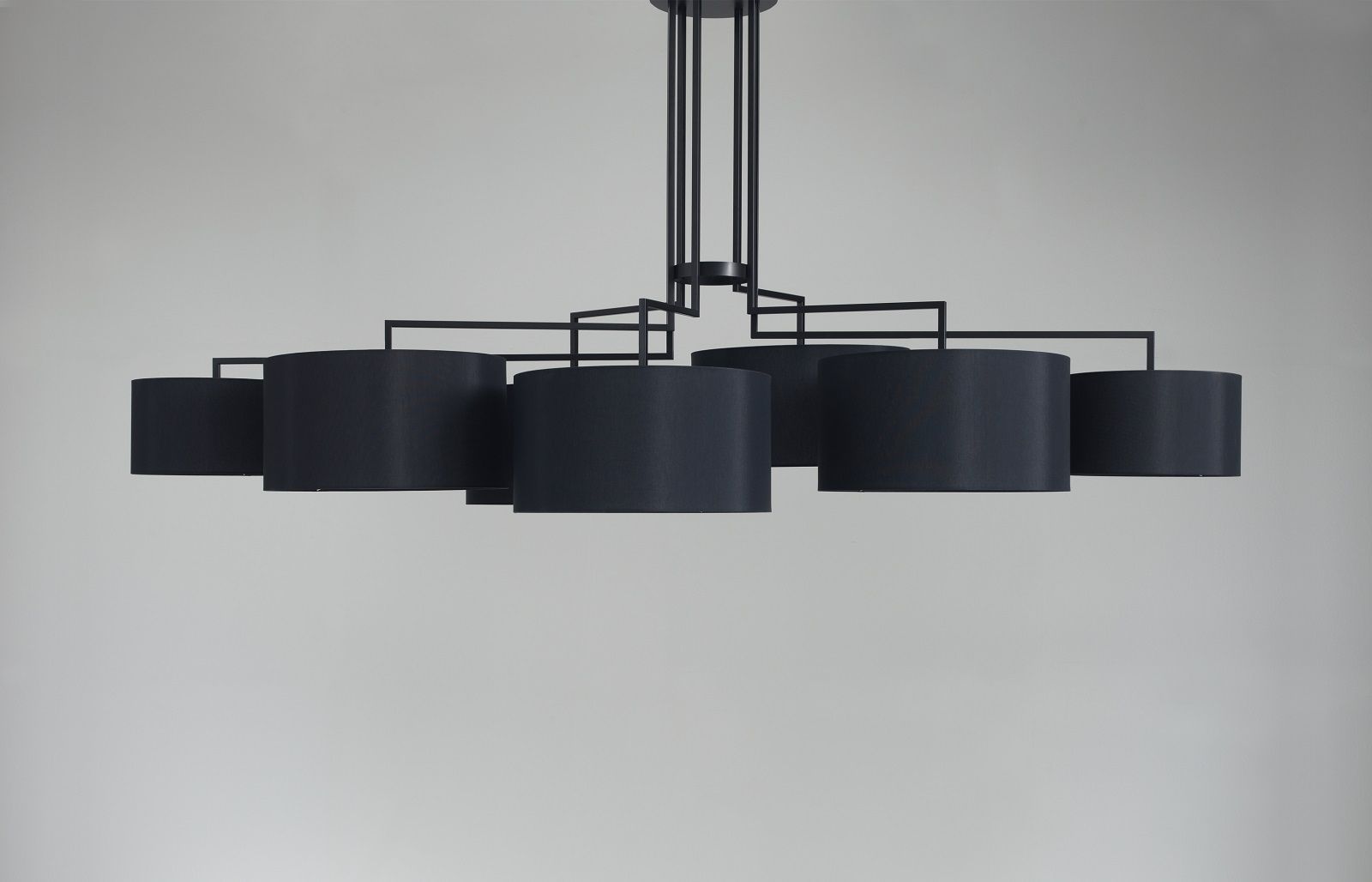 Schwarze NOON 7 Deckenleuchte von Zeitraum mit sieben zylindrischen Lampenschirmen und filigranem Metallgestell.