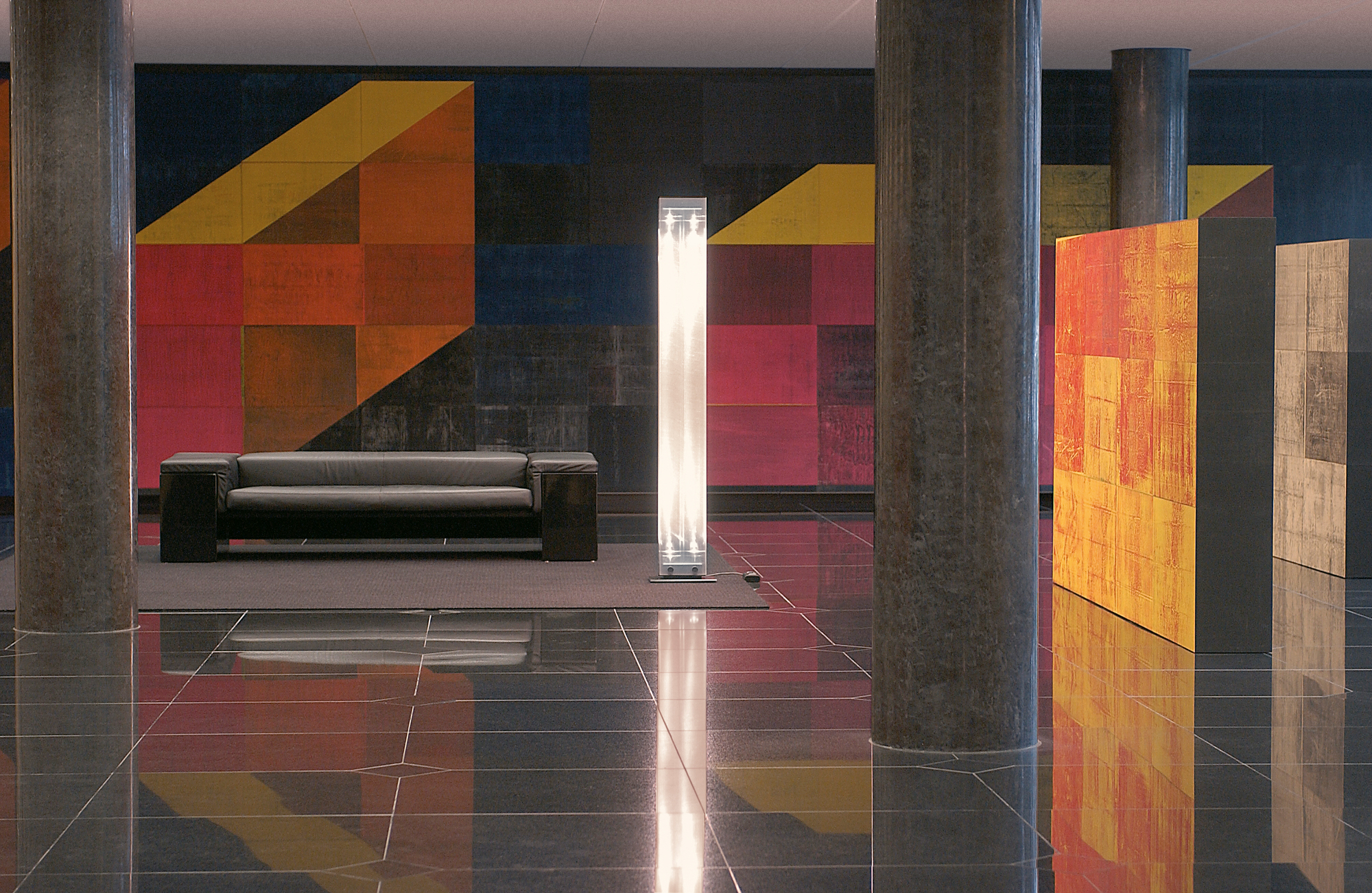 Twilight LED Stehleuchte von Belux in modernem Interieur mit Sofa und Kunstinstallation.