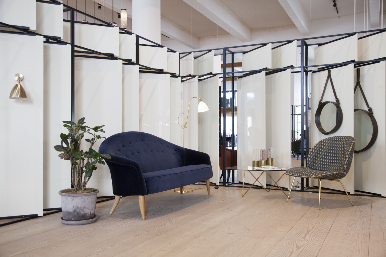 Bestlite BL3 Stehleuchte in Bone China/Chrom neben blauem Sofa und Glas-Couchtisch.