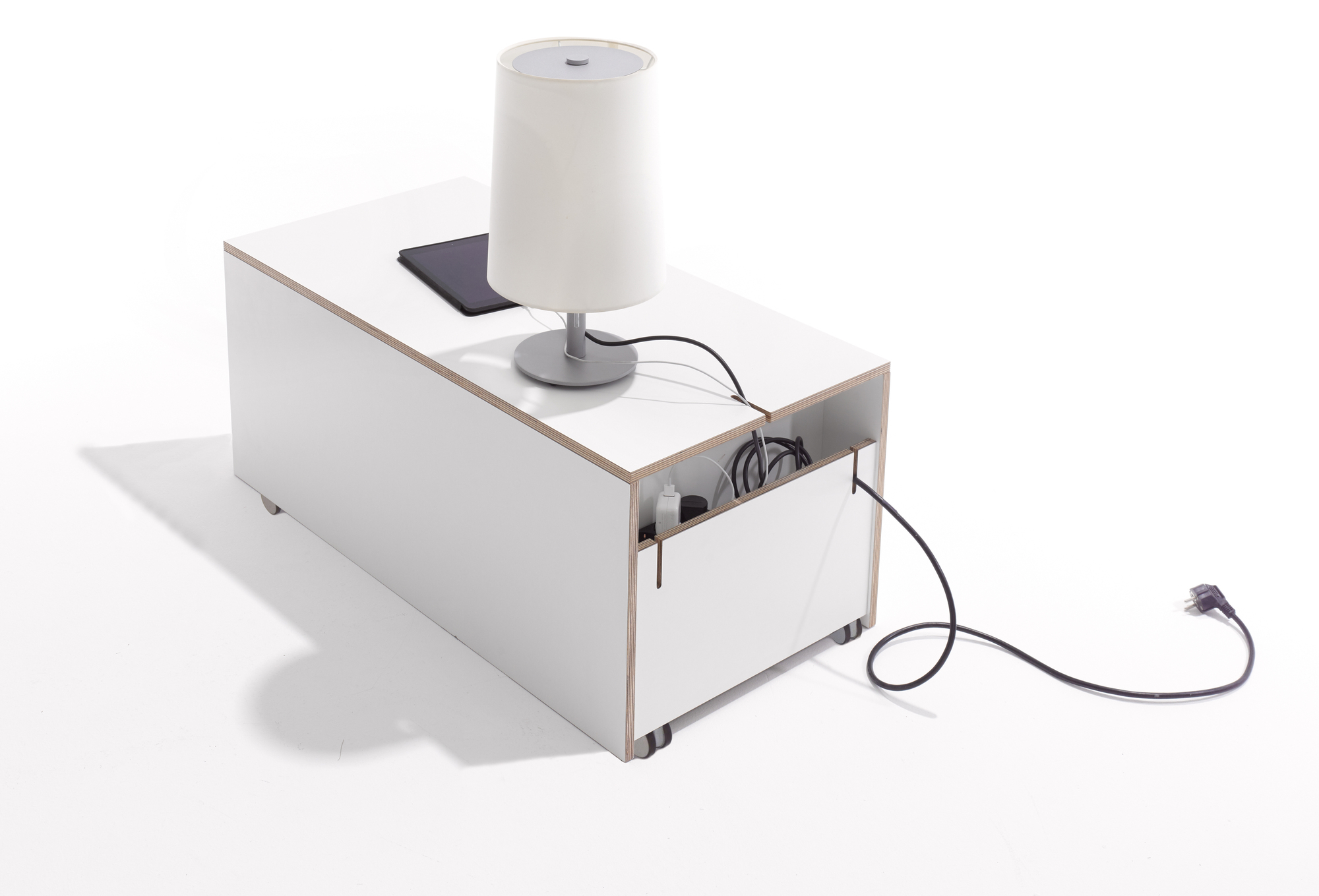 Weißer Nachttisch "Komfort Bettkasten" von Müller Möbelwerkstätten mit Schublade, Rollen und Lampe.