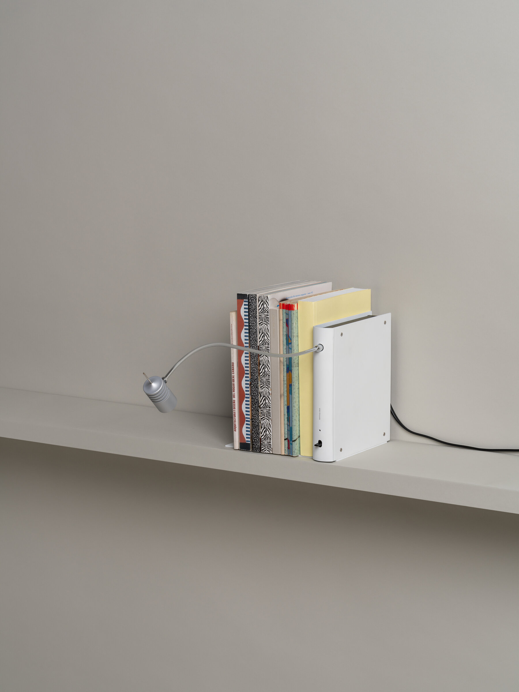 Bib Luz Tischleuchte von Santa & Cole in Off White als Buchstütze mit flexiblem Arm.