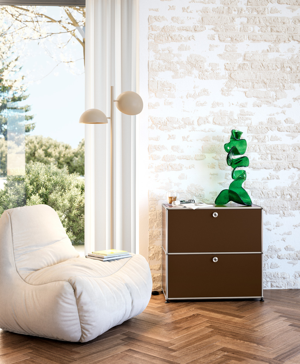 Kleines, braunes USM Haller Sideboard mit zwei Fächern im modernen Wohnzimmer mit Sessel und Dekoration.