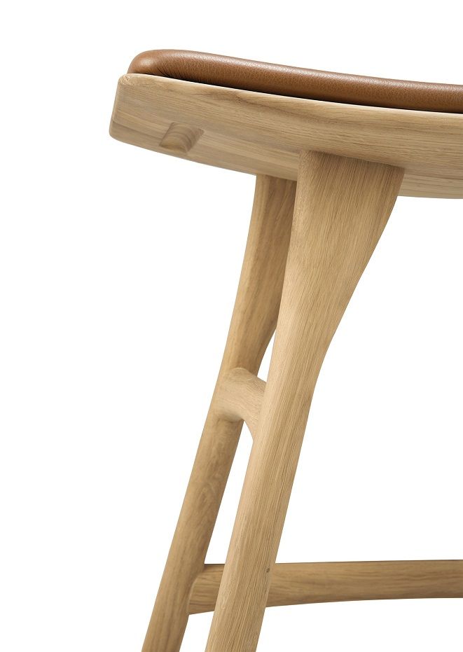 Detailaufnahme des Osso Hockers von Ethnicraft: Eiche-Holzgestell mit braunem Ledersitzpolster. Modernes Möbeldesign.