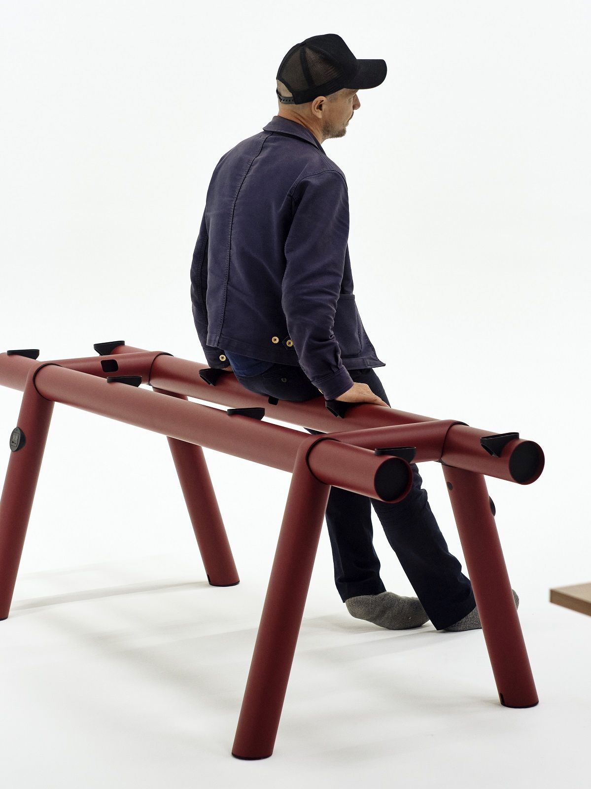 Roter Boa Table Tisch von Hay, 220 cm breit, mit Person darauf sitzend. Moderner Esstisch.