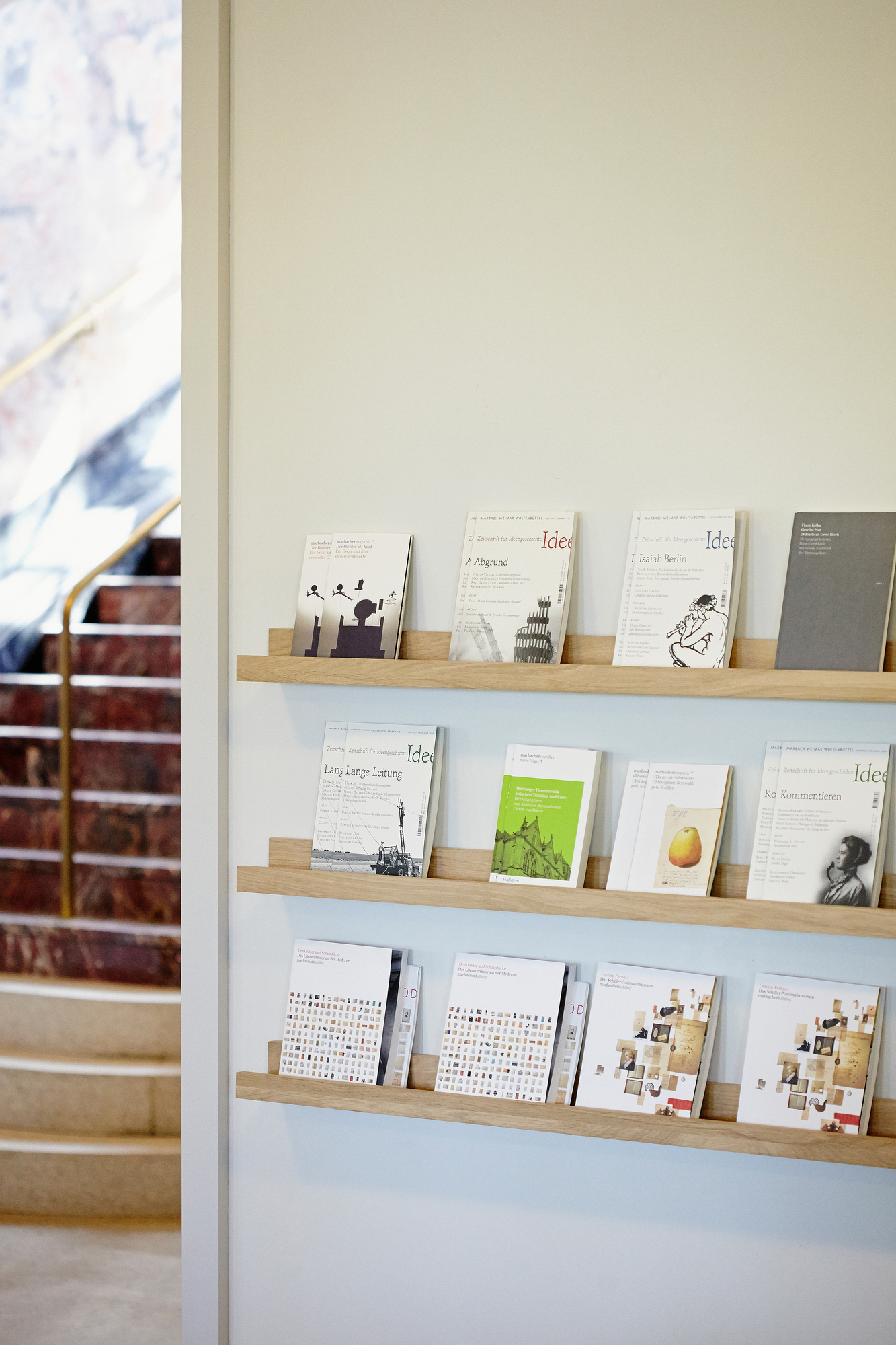 Nahaufnahme: Jan Kurtz Ell Wandregal aus Holz mit Zeitschriften, Bücherregal, modernes Design.