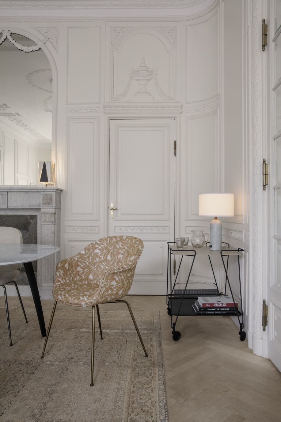 Weiße Gravity Tischleuchte von Gubi mit Marmorfuß und Stoffschirm auf einem Servierwagen.