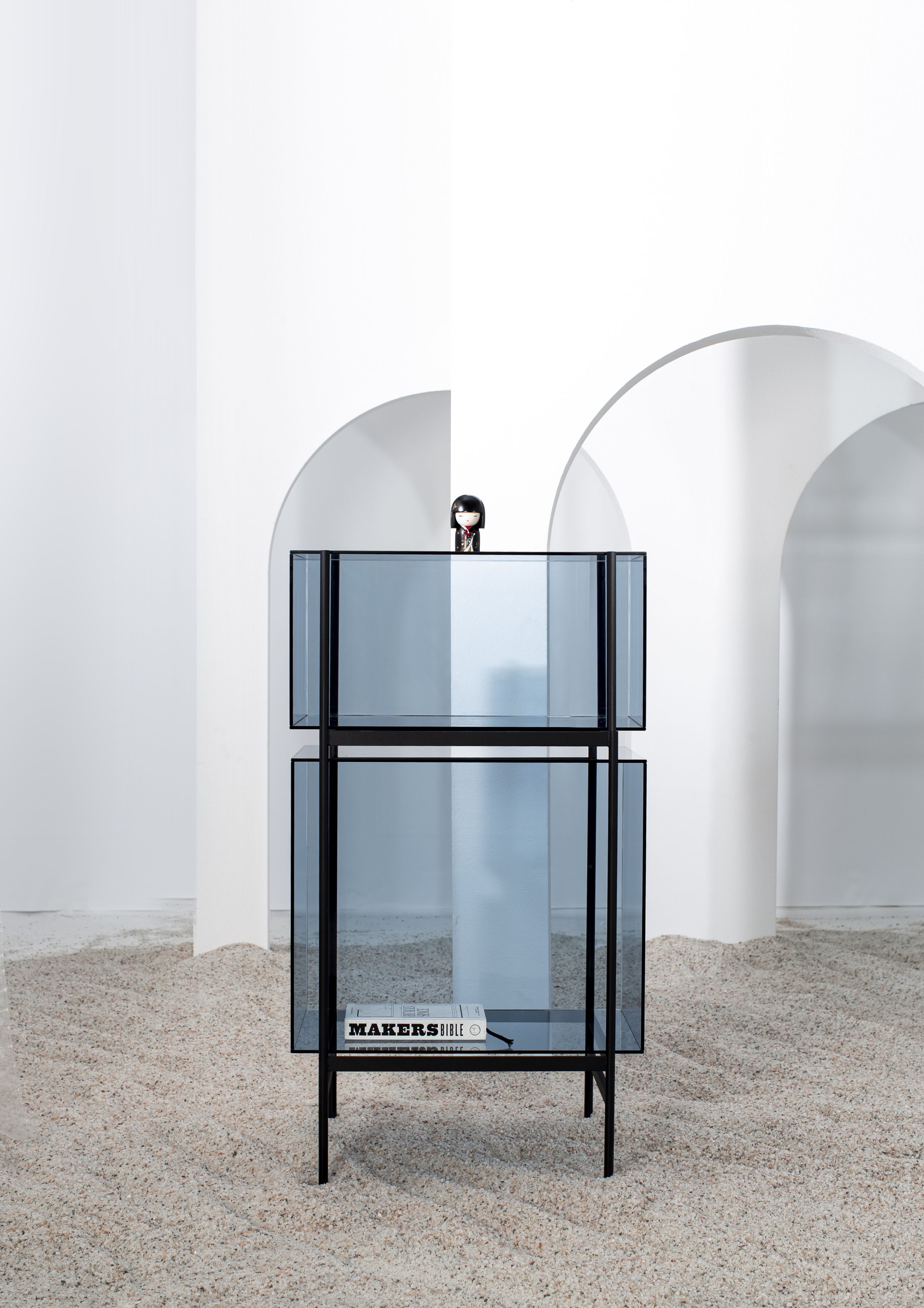 Lyn Regal blau von Pulpo: Kleines, modernes Glasregal mit zwei Ebenen und schwarzem Rahmen.