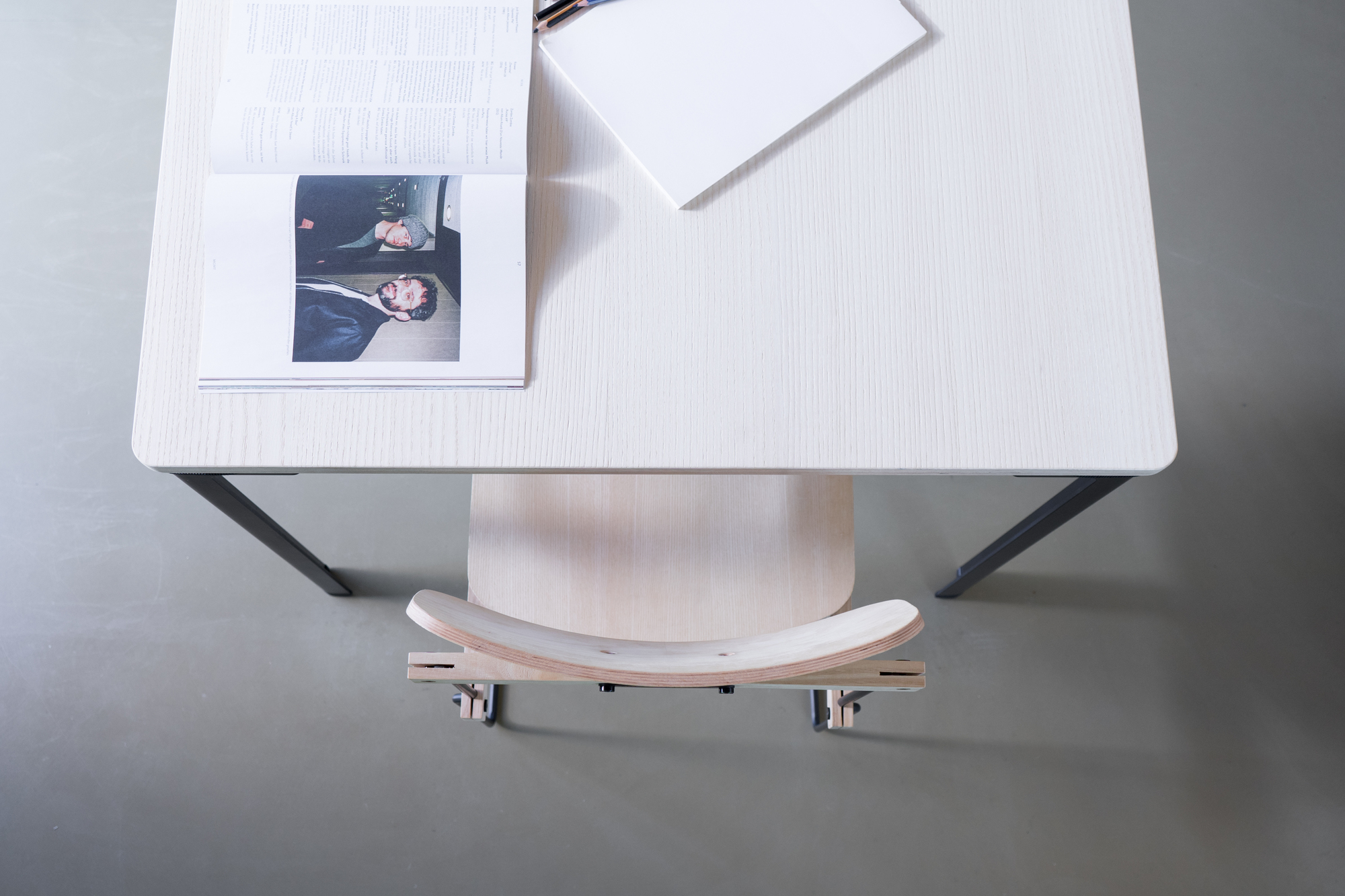 Ansicht von oben: Heller Bruto Stuhl ohne Armlehne von Nils Holger Moormann unter einem Schreibtisch.