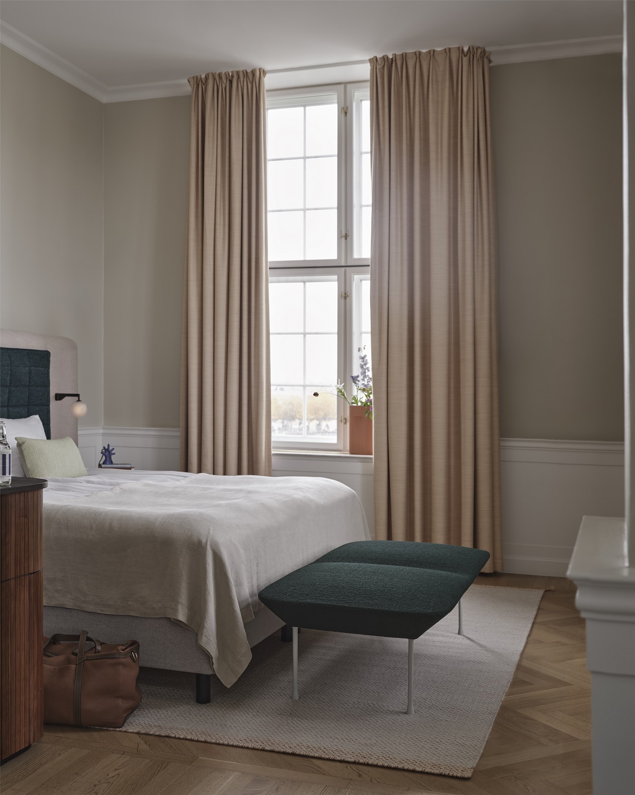 Schlafzimmer mit Oslo Bench Bank von Muuto in dunklem Grün vor einem Bett.