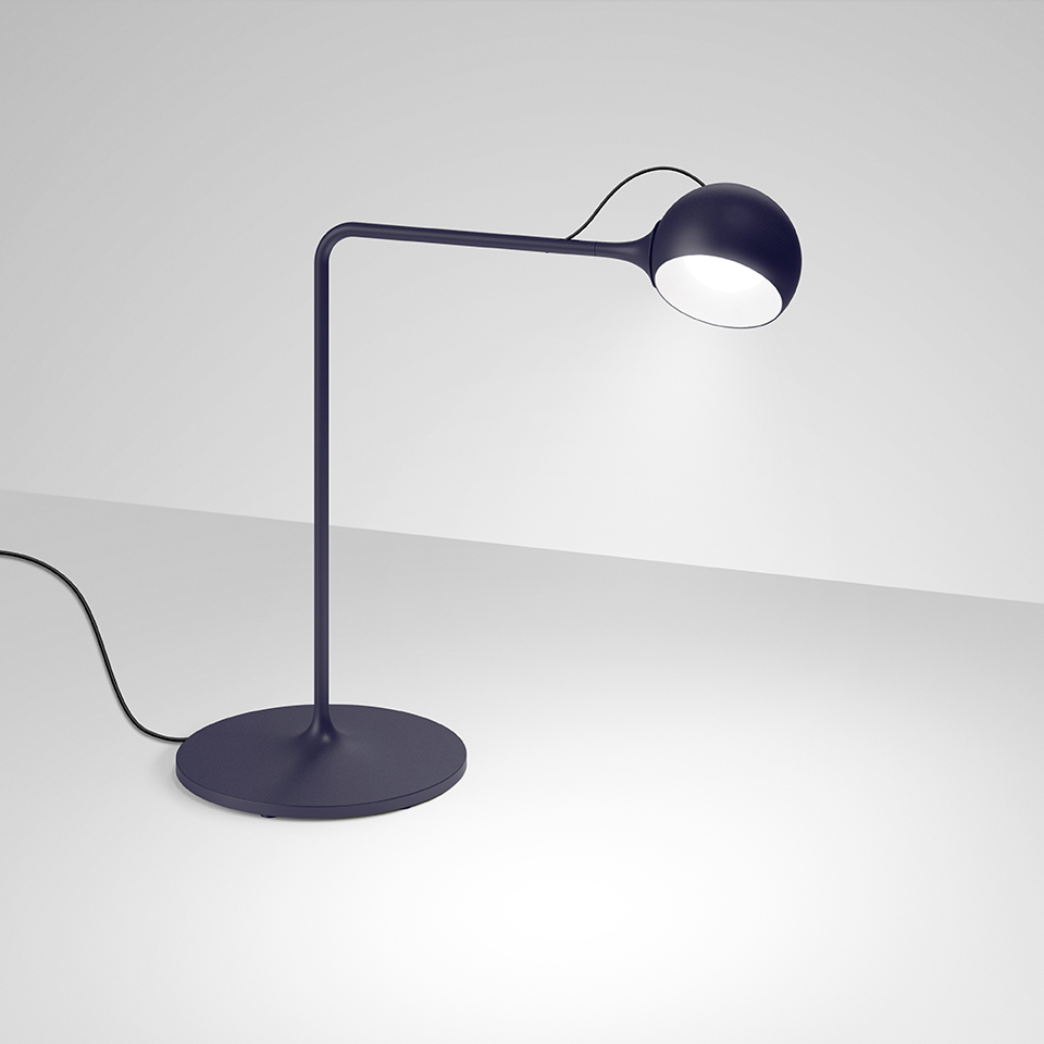 Blaue Ixa Tischleuchte von Artemide: Moderne Schreibtischlampe mit rundem Lampenschirm und minimalistischem Design.