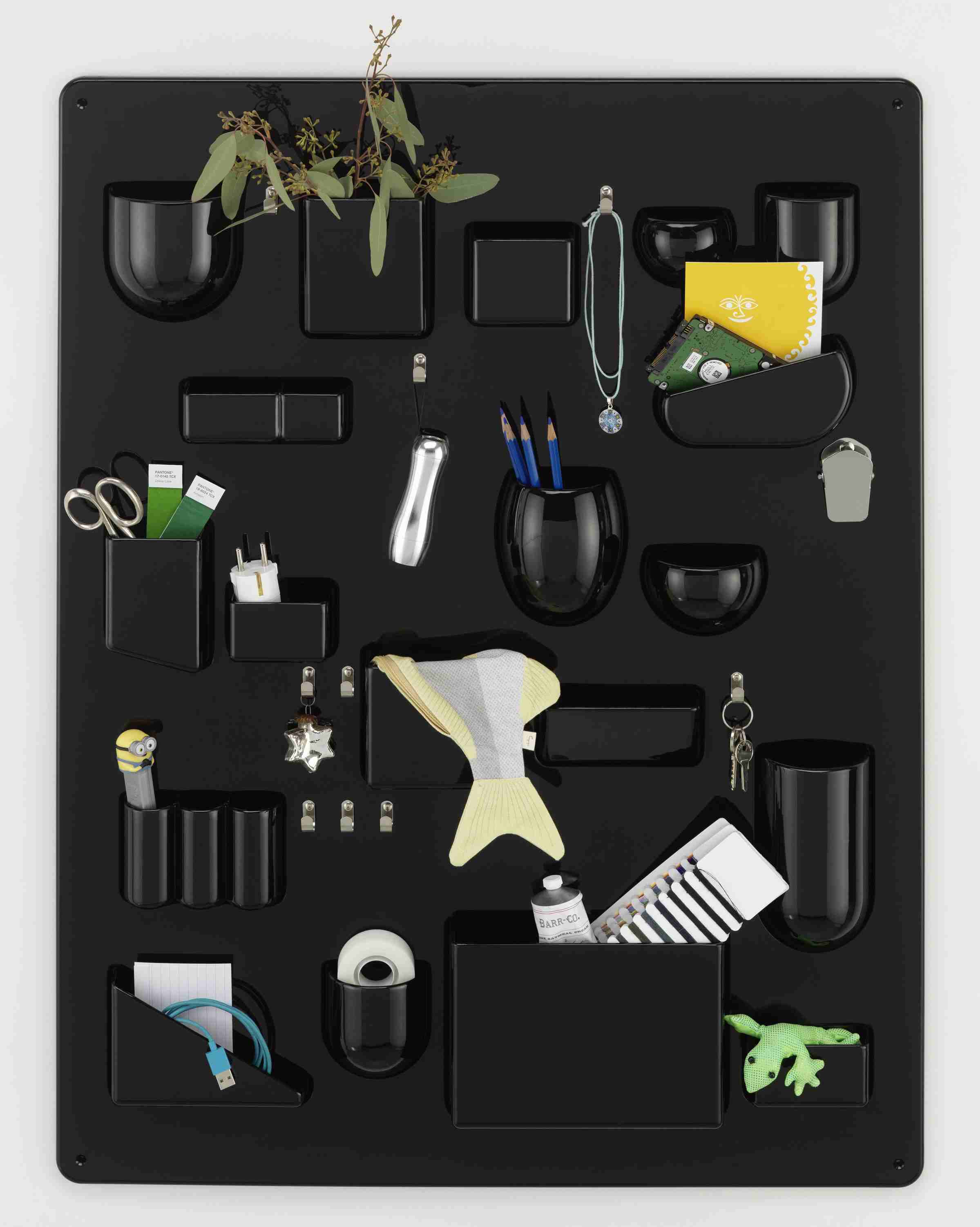 Schwarzes Uten.Silo Wand-Ordnungssystem von Vitra, gefüllt mit Büroartikeln, Pflanzen und Dekoration, zur stilvollen Aufbewahrung von Alltagsgegenständen.