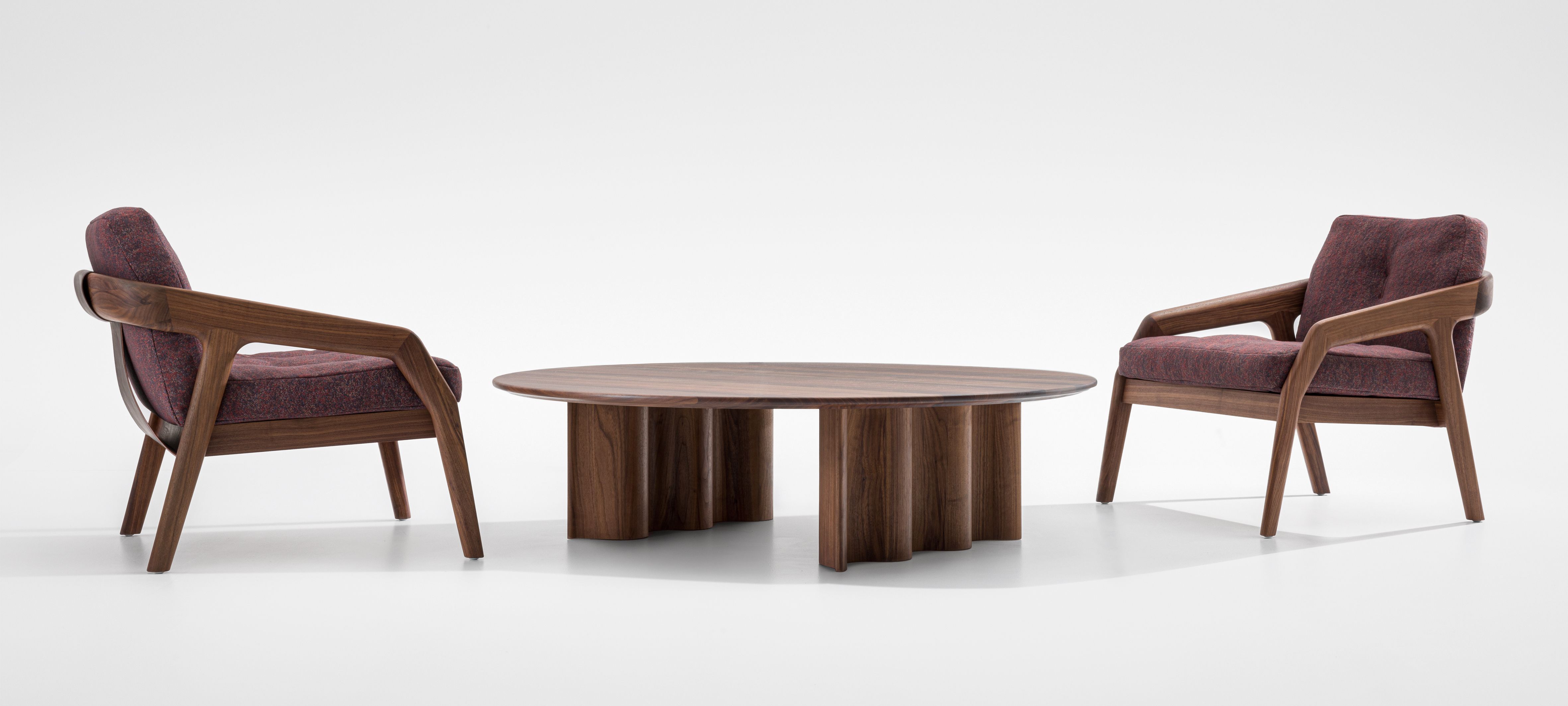 Curtain Couchtisch Rund Walnuss mit zwei passenden Sesseln auf einem weißen Hintergrund. Modernes Wohnzimmer Design.