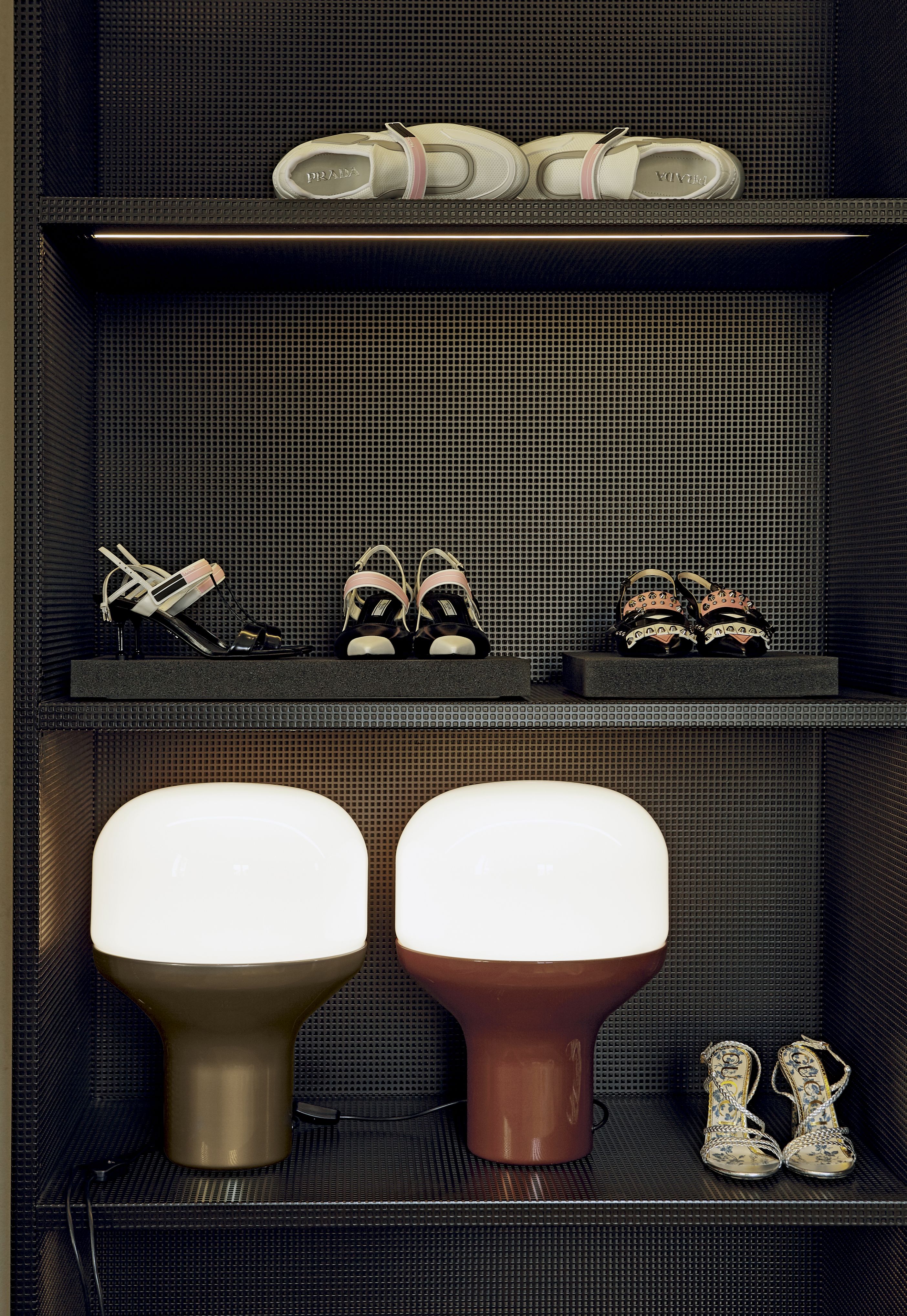 Delux Tischleuchte Sandgold von Martinelli Luce auf einem Regal mit Schuhen. Moderne Tischlampe.