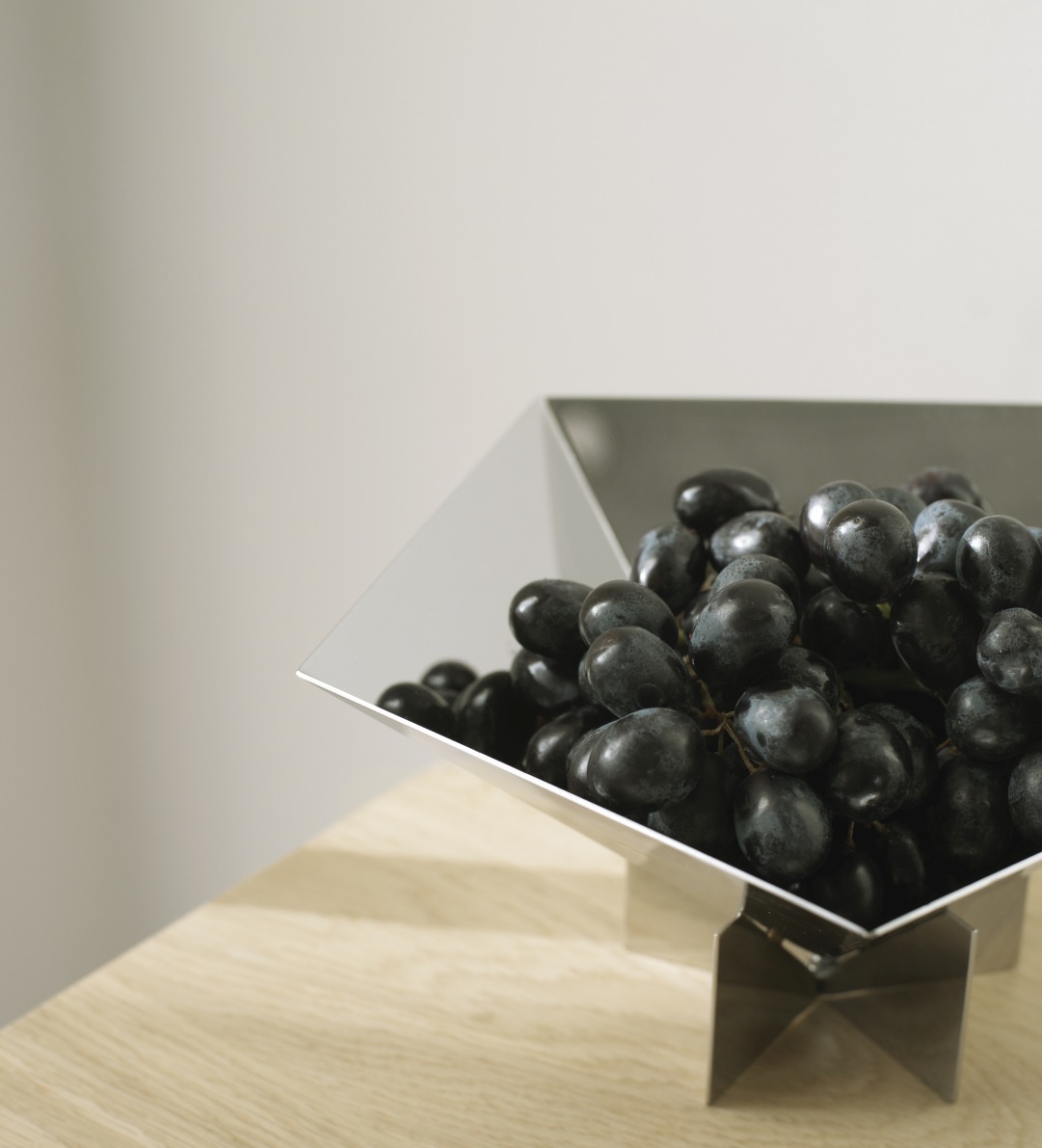 Nahaufnahme der Fem Schale von Normann Copenhagen aus Edelstahl, gefüllt mit dunklen Trauben.