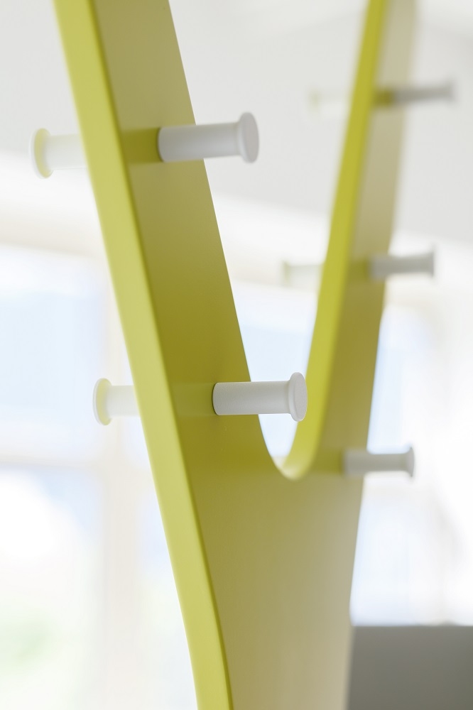 Nahaufnahme der modernen, gelben Tree Standgarderobe von Cascando mit weißen Haken für Jacken und Mäntel.