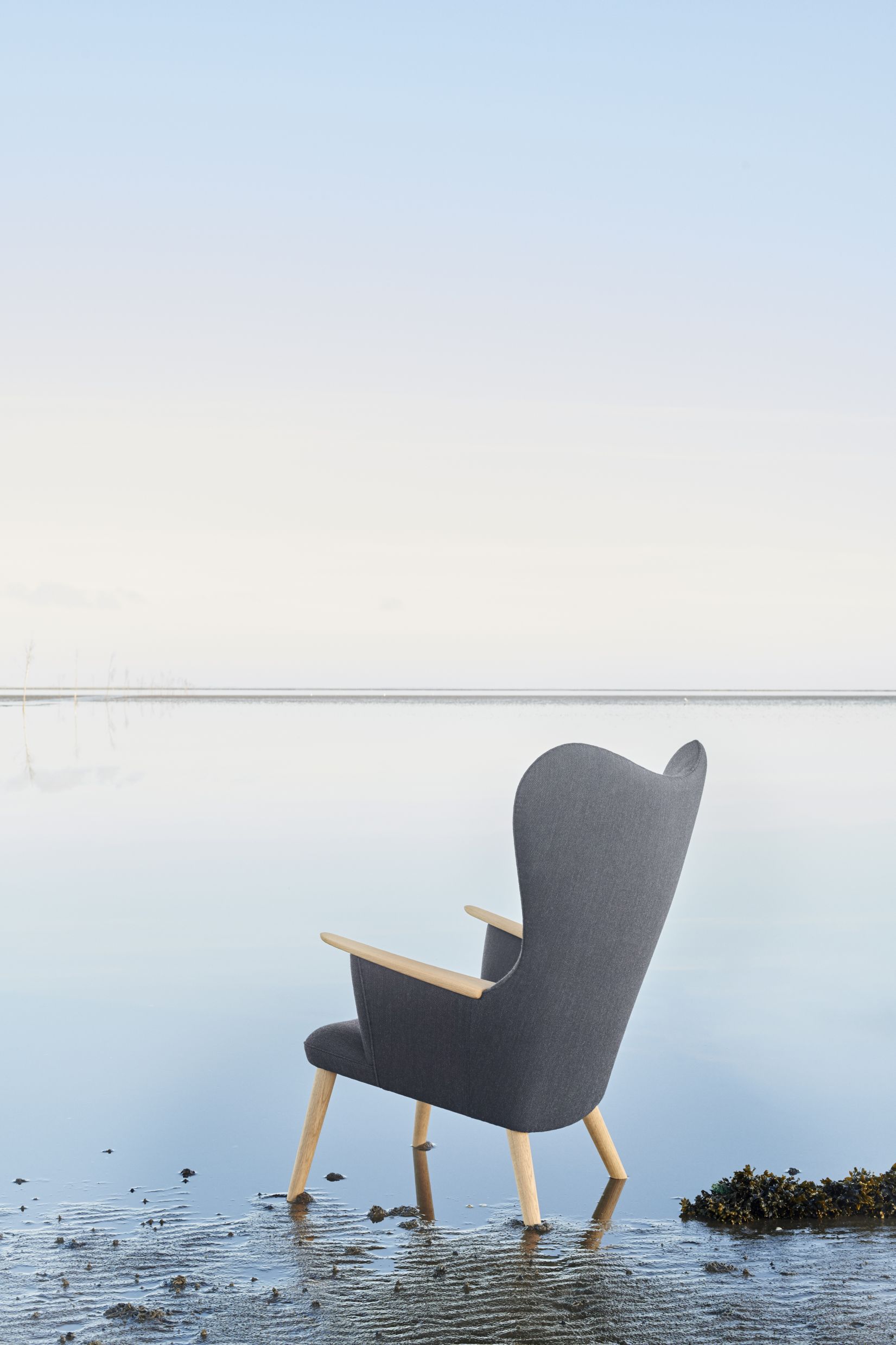 CH78 Mama Bear Sessel von Carl Hansen & Søn, grauer Lounge Sessel am Strand.