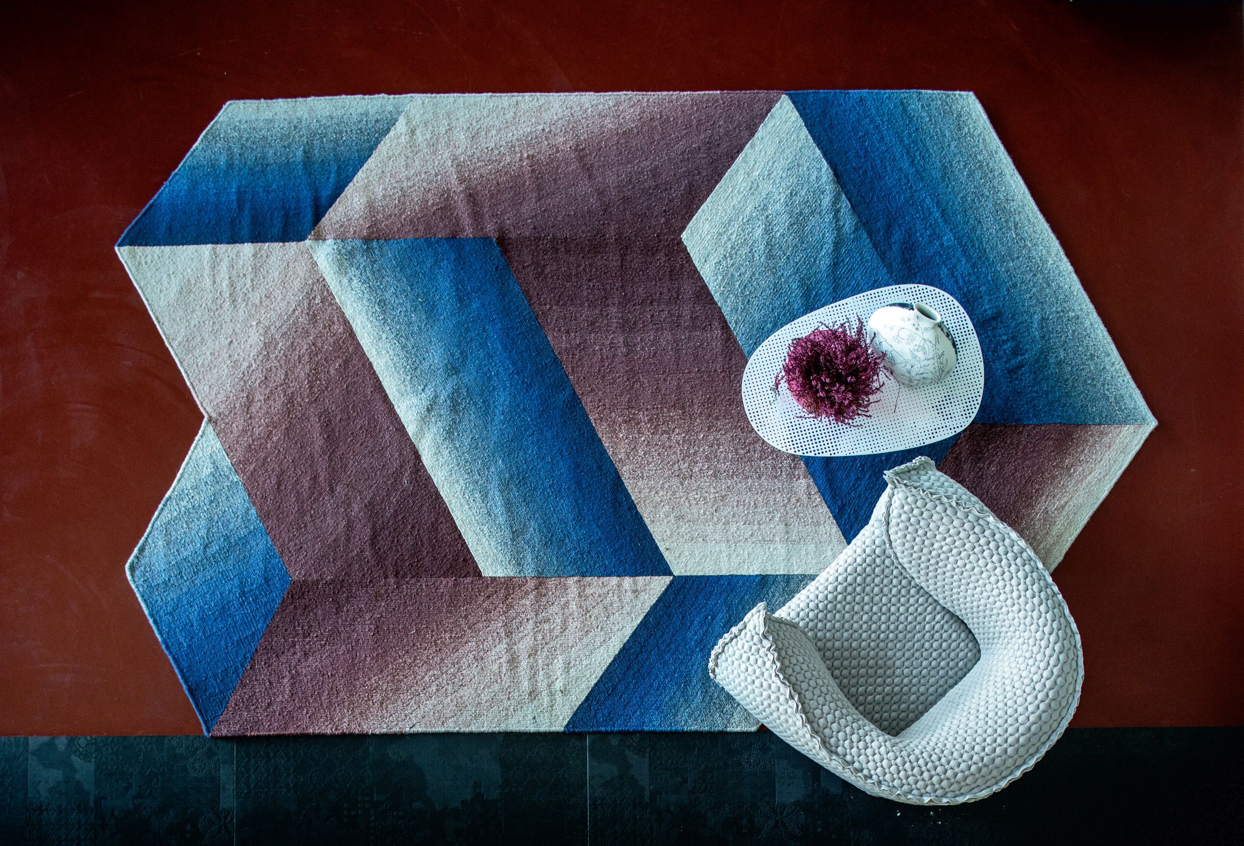 Cloud Tisch Moroso: Detailaufnahme eines modernen Teppichs mit geometrischem Muster in Blau- und Lilatönen.