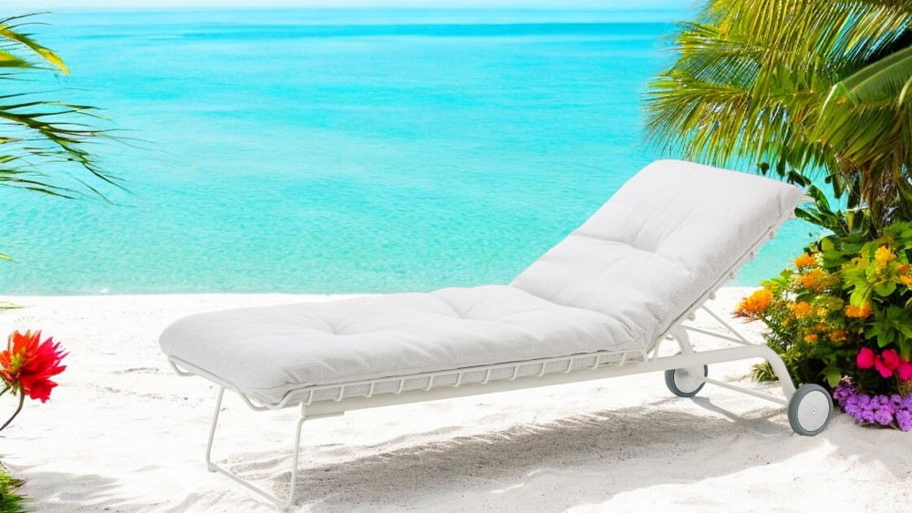 Weiße Leyasol Sonnenliege von Freifrau Manufaktur am Strand mit Meer und Palmen im Hintergrund.