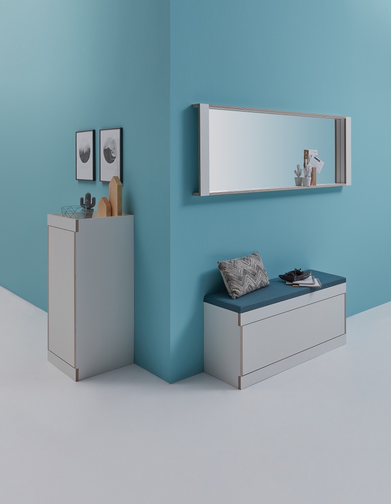 Helle Flai Stauraumbank von Müller Möbelwerkstätten mit blauem Sitzkissen und passendem Schrank.