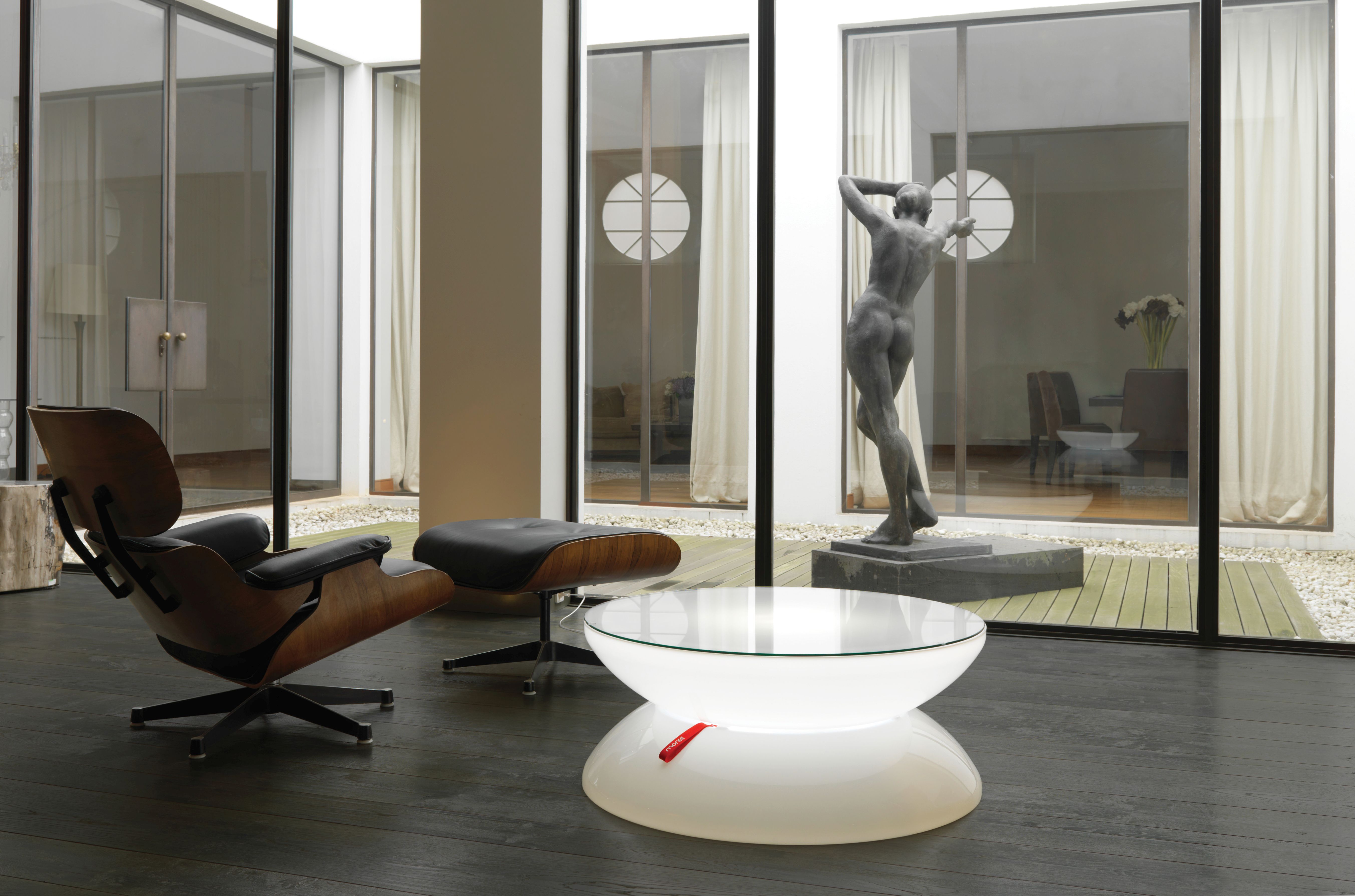 Moderner Wohnraum mit Moree Lounge Tisch, Design Sessel und Skulptur am Fenster.