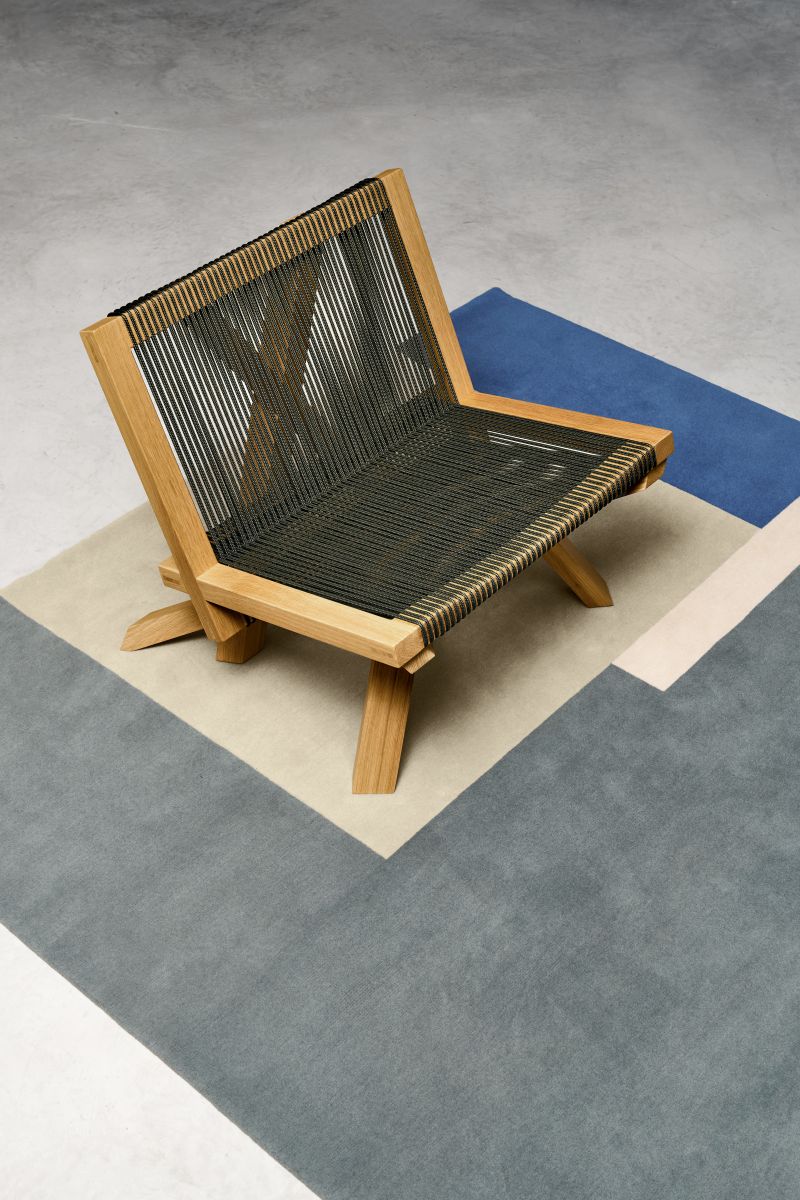 ClassiCon Volkshaus Lounge Chair Sessel mit Holzrahmen und geflochtener Sitzfläche auf modernem Teppich.