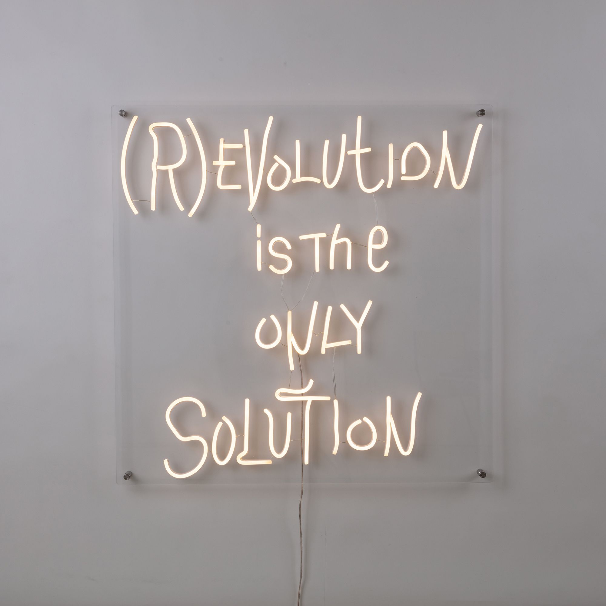 Seletti Revolution LED Wandleuchte: Neon-Schriftzug "Revolution is the only solution" auf transparentem Acryl.