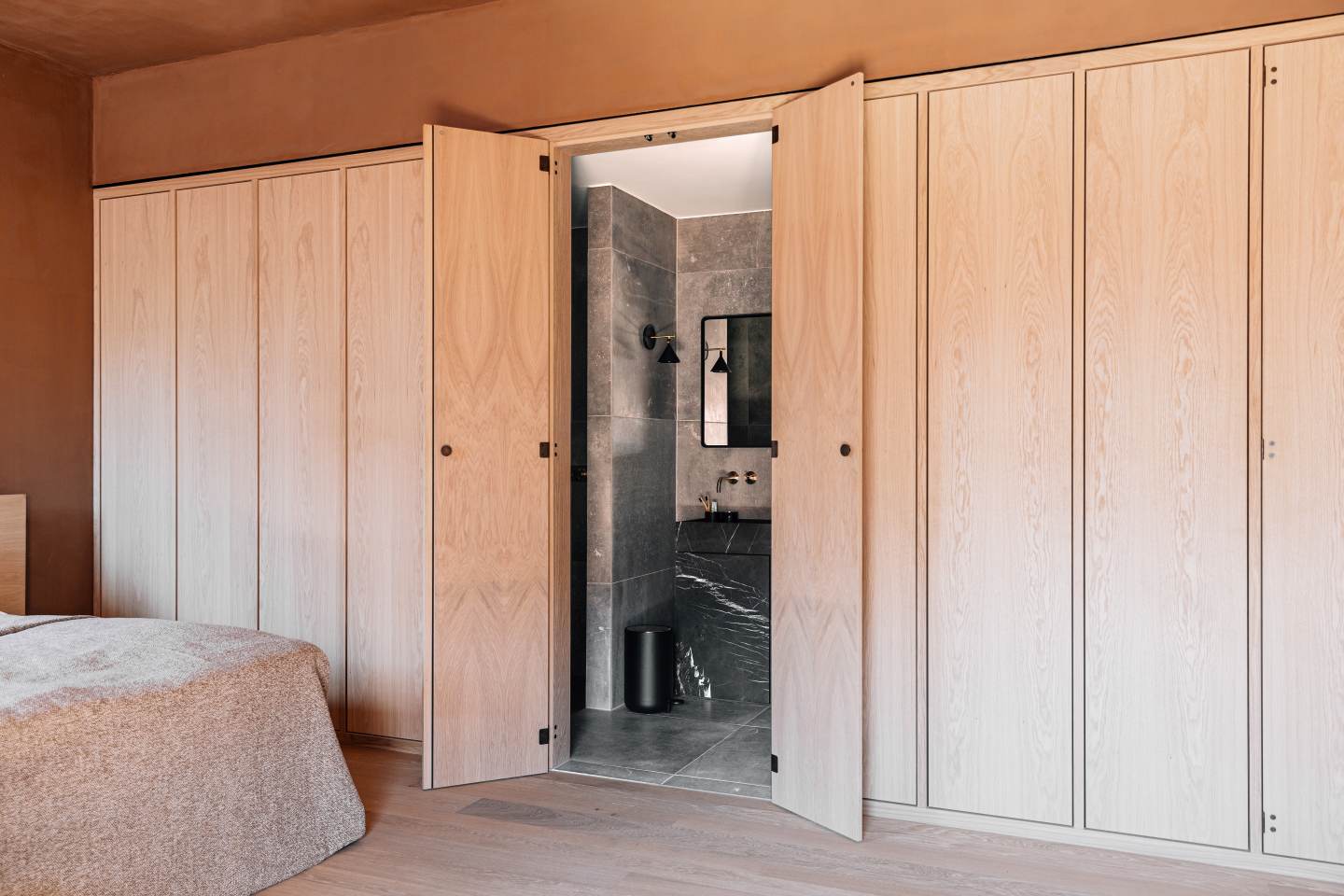 Badezimmer mit Audo Norm Wandspiegel rechteckig, montiert über einem modernen Marmorwaschtisch.