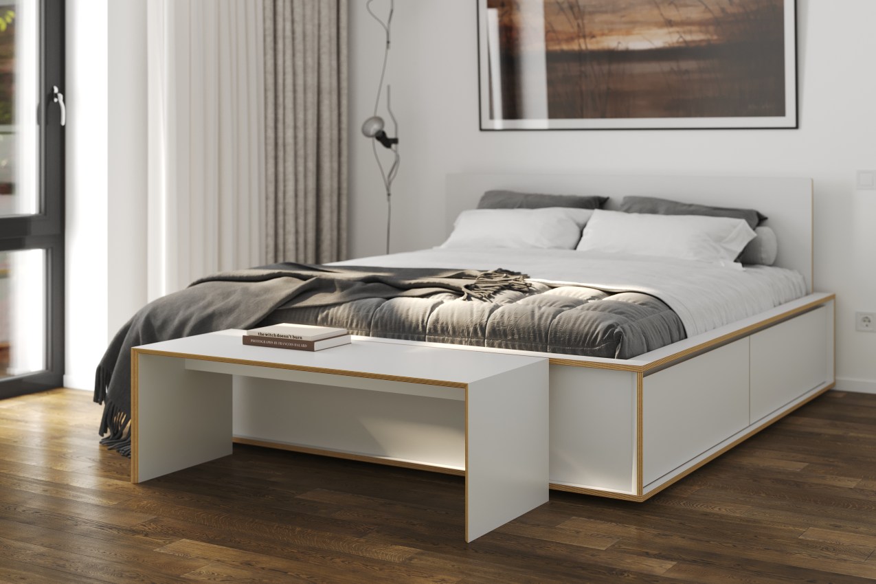 Weiße Bridge Sitzbank von Müller Möbelwerkstätten als Beistelltisch vor einem Bett.