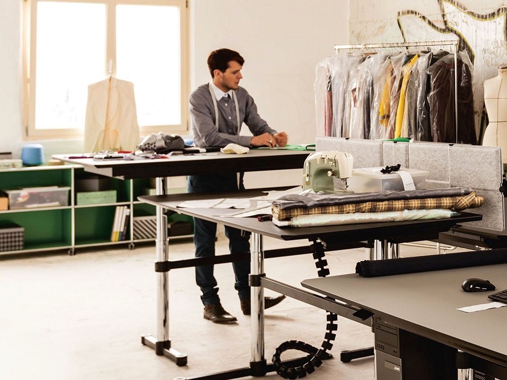 USM Haller Regal im Schneideratelier: Offenes Sideboard in Grün mit Fächern und Rollen.