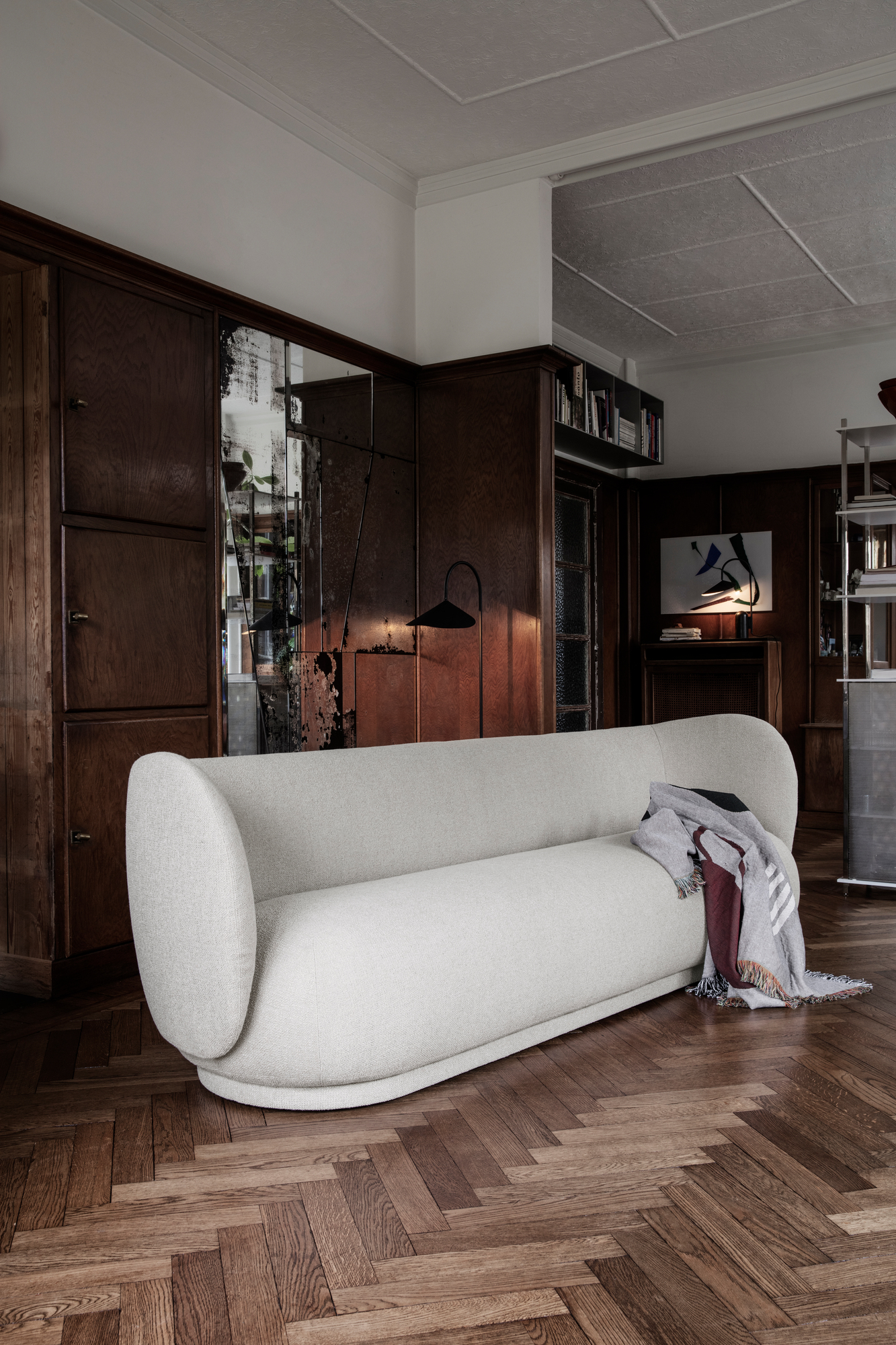 Arum Stehleuchte von Ferm Living im Wohnzimmer mit Sofa und dunkler Holzvertäfelung.