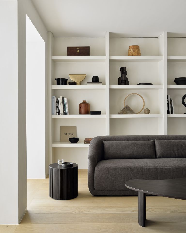 Nahaufnahme: Runder, dunkelbrauner Ethnicraft Beistelltisch "Roller Max" im modernen Wohnzimmer.