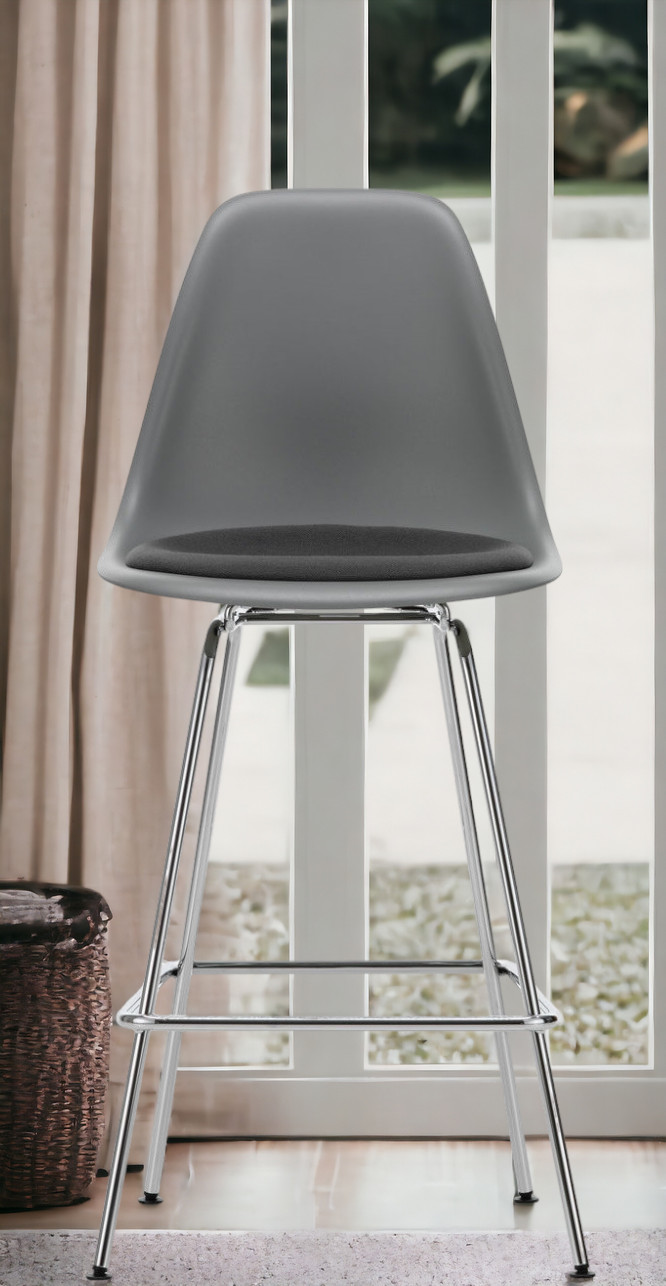 Grauer Eames Plastic Bar Stool Barhocker von Vitra mit Sitzpolster und verchromtem Gestell.