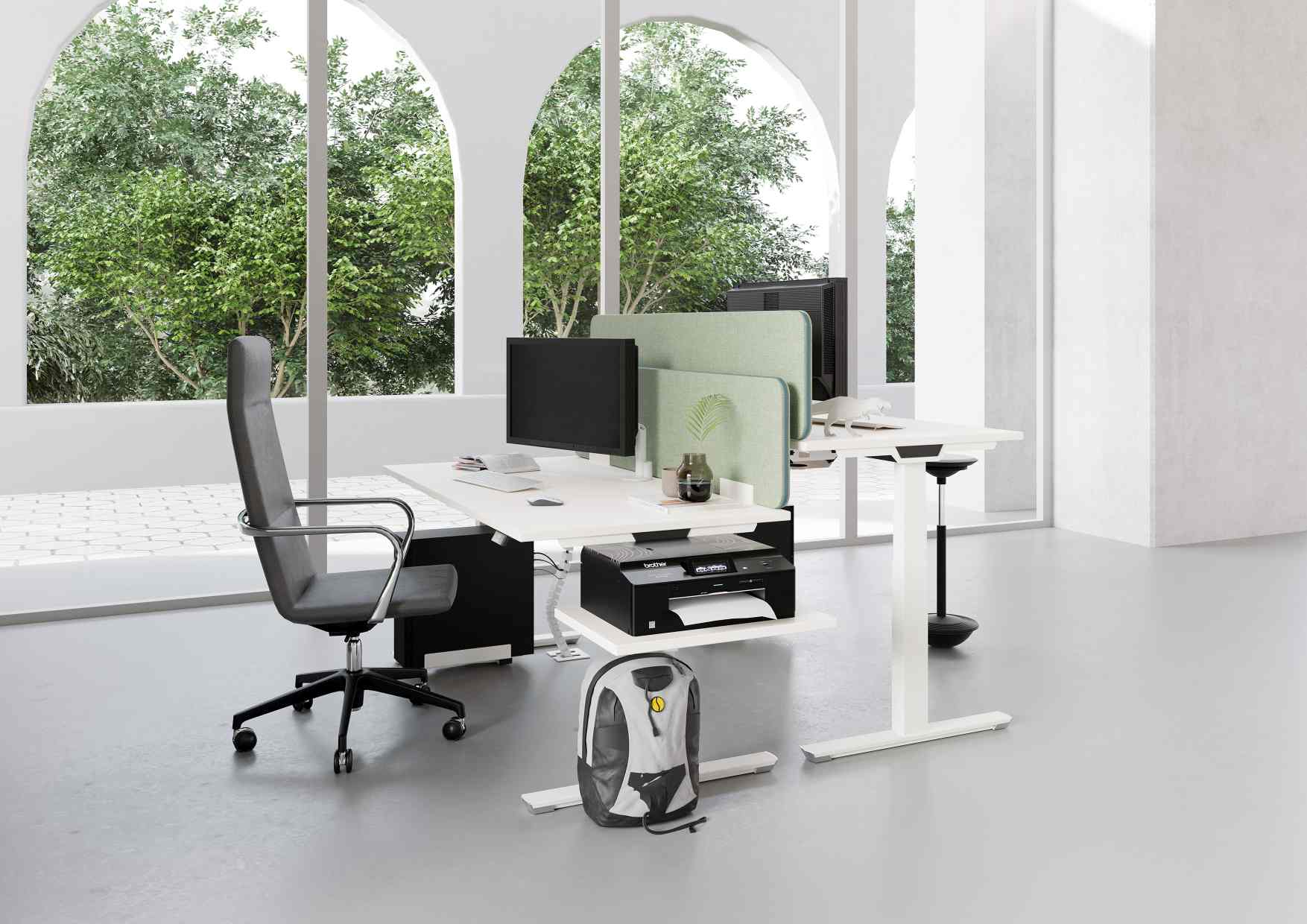 Heller Raum mit Palmberg Crew T Schreibtisch, höhenverstellbar, weiß, mit Monitoren und Bürostuhl.