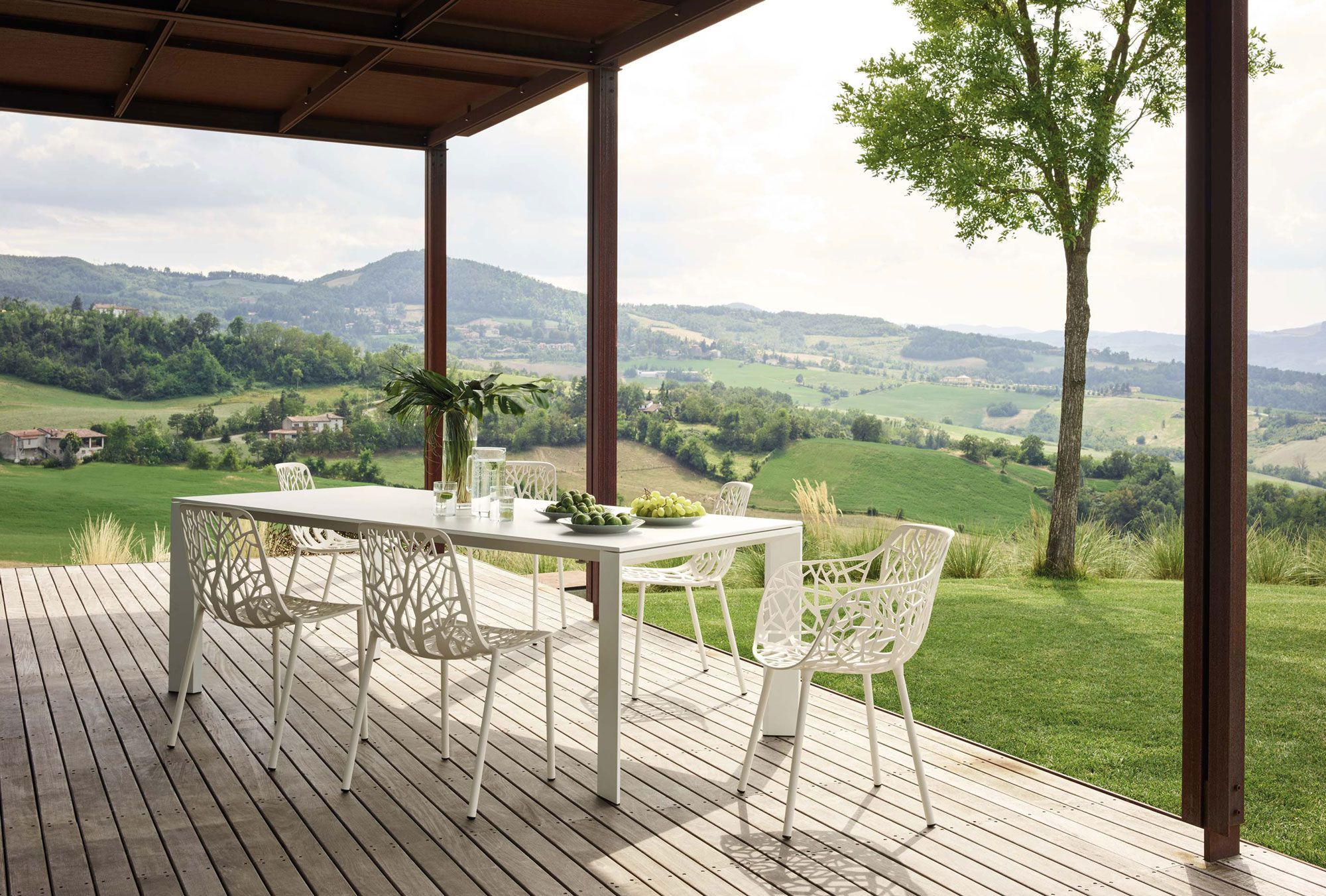 Weißer Forest Outdoor Stuhl von Fast am Esstisch auf einer Terrasse mit Landschaftsblick.
