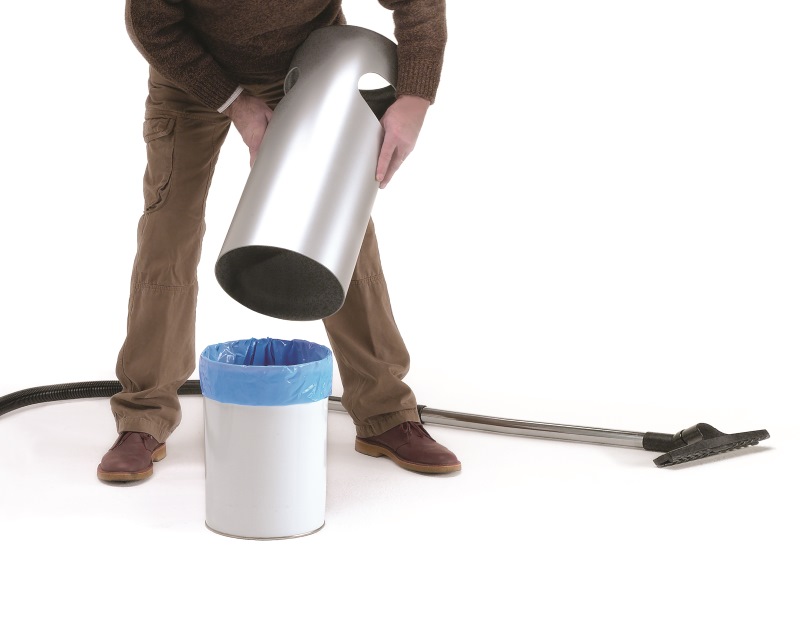 Mann leert Rexite Birillo Plus Papierkorb. Silberner Behälter über weißem Eimer mit blauem Müllbeutel.