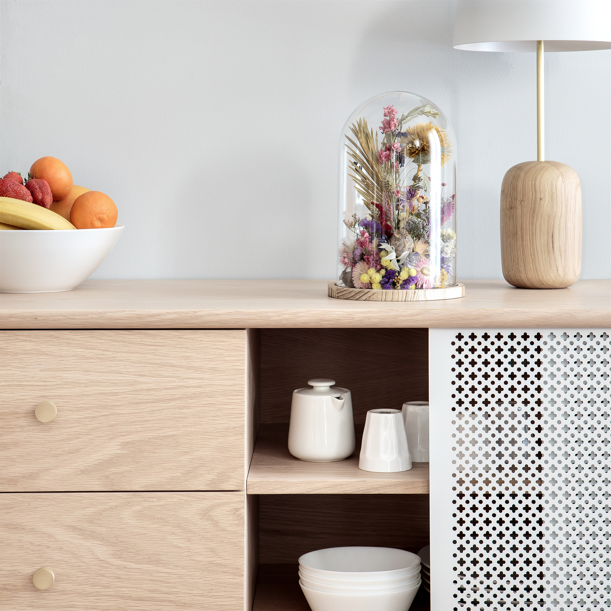 Gabin Sideboard von Hartô aus hellem Holz mit Schubladen und floralen Dekorationen.