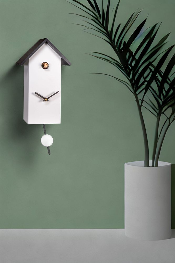 Weiße Engstler Kuckucksuhr mit Pendel und schwarzem Dach vor grüner Wand. Dekorative Wanduhr.