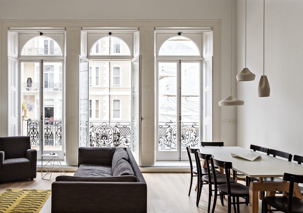 Helle Wohnung mit Pleat Box Pendelleuchten von Marset in Weiß über einem Esstisch.