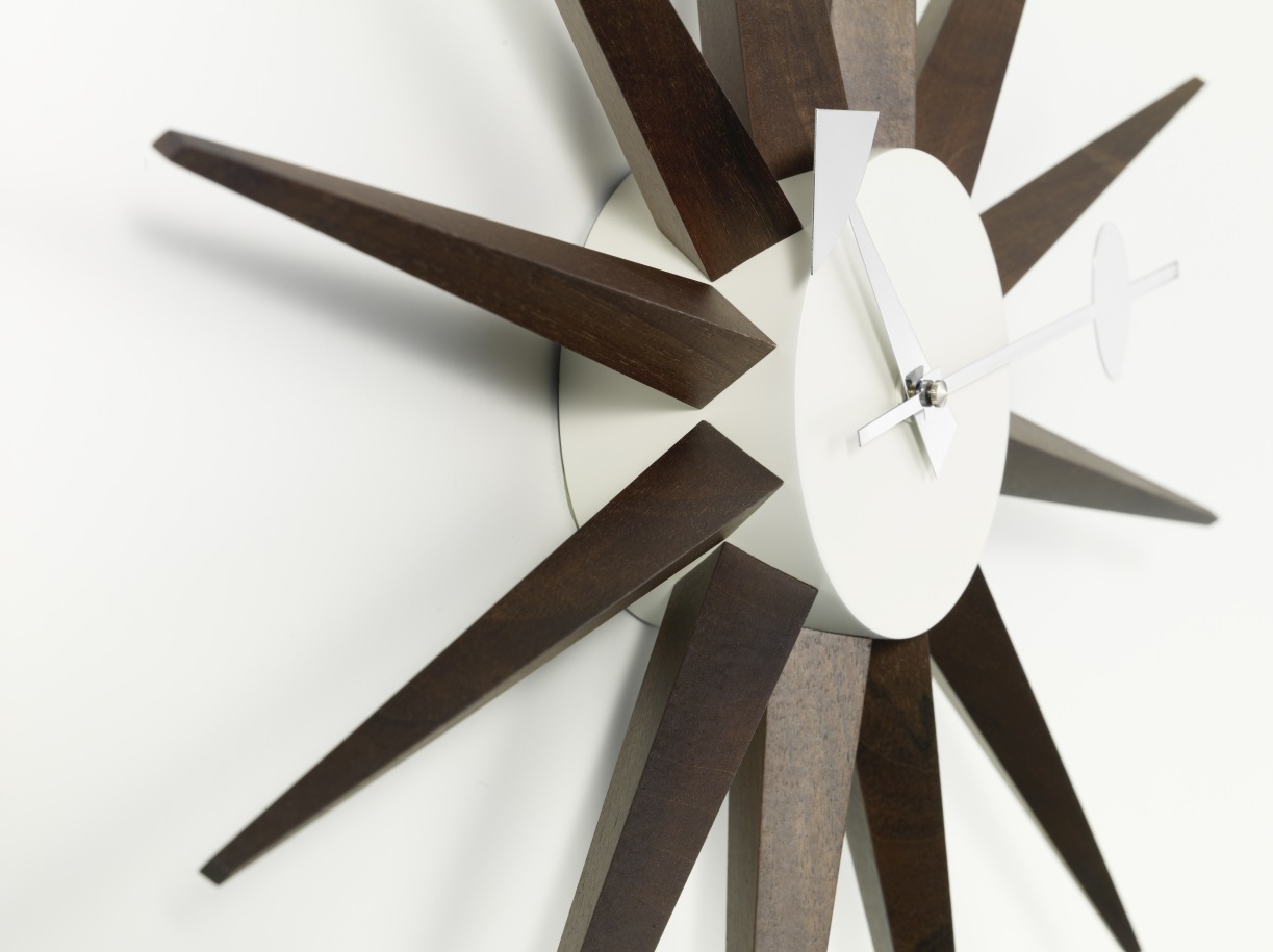 Detailaufnahme der Sunburst Clock Wanduhr mit Nussbaum-Elementen von Vitra, modernes Design für Wohnzimmer und Büro.