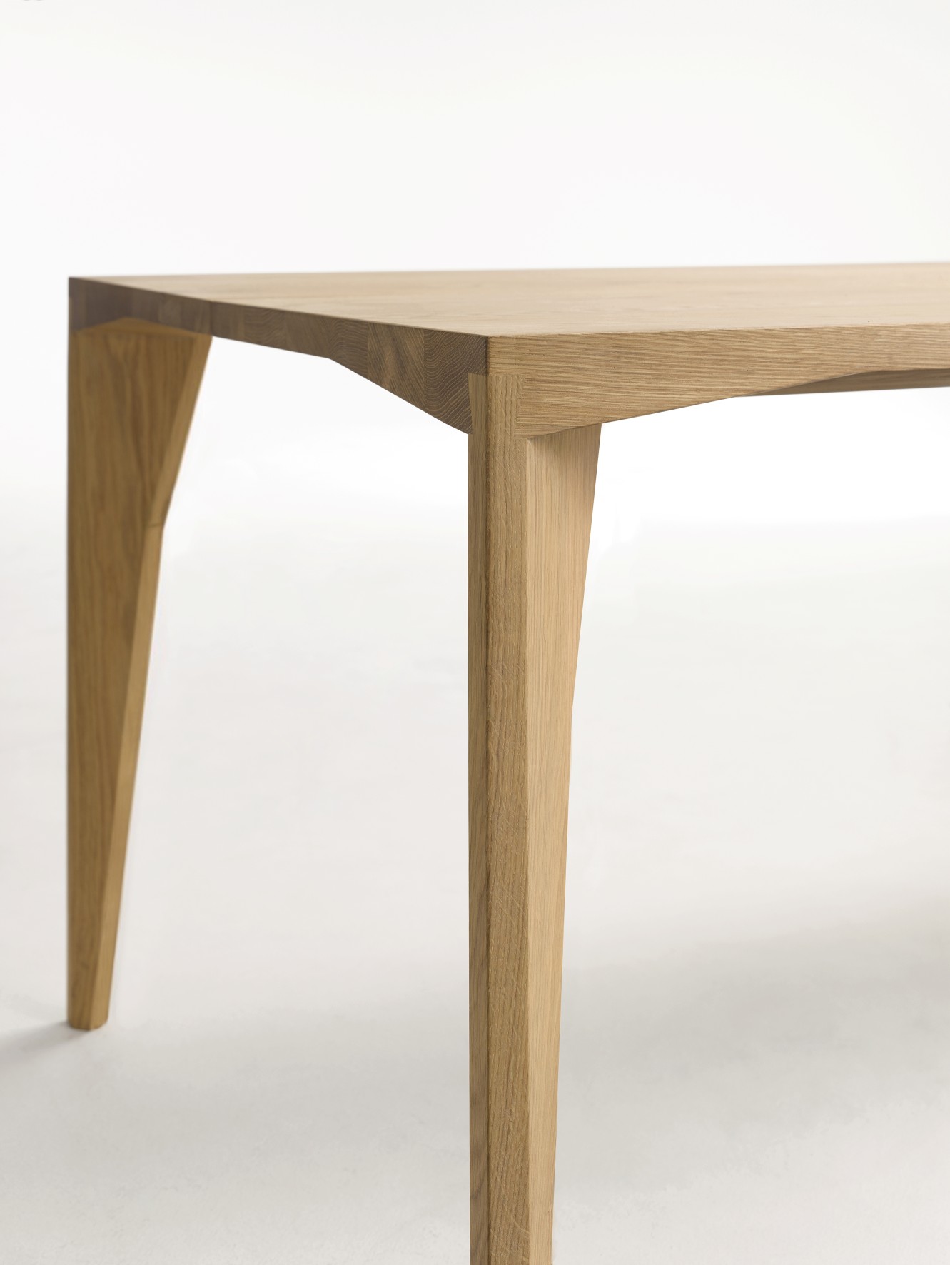 Detailaufnahme vom Delta Tisch von Cor: Moderner Esstisch aus hellem Holz mit markanten Tischbeinen.