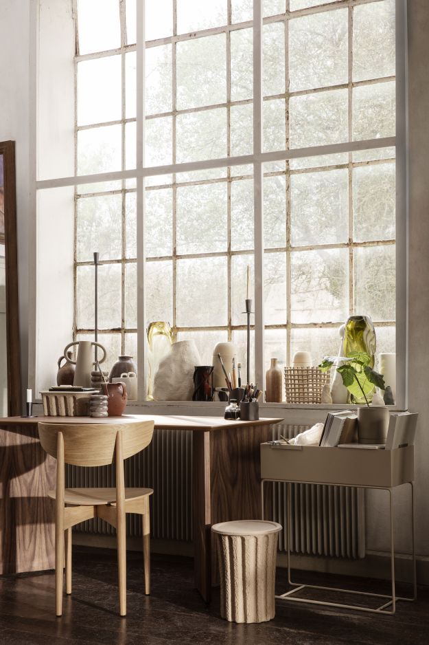 Ferm Living Mingle Table: Schreibtisch aus Holz mit Stuhl und Dekoration vor großem Fenster.