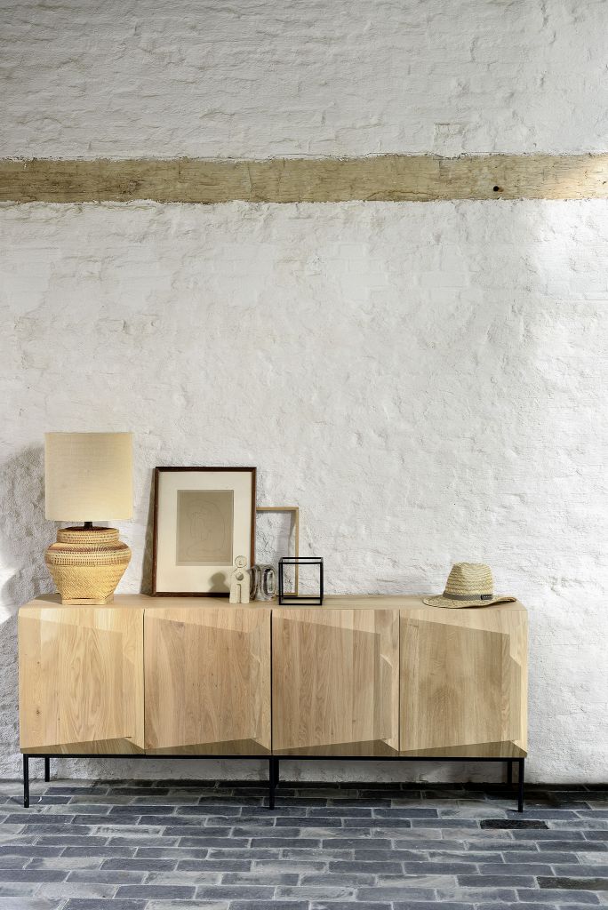 Ethnicraft Stairs Anrichte aus Eiche mit vier Türen und schwarzem Metallgestell vor weißer Wand.