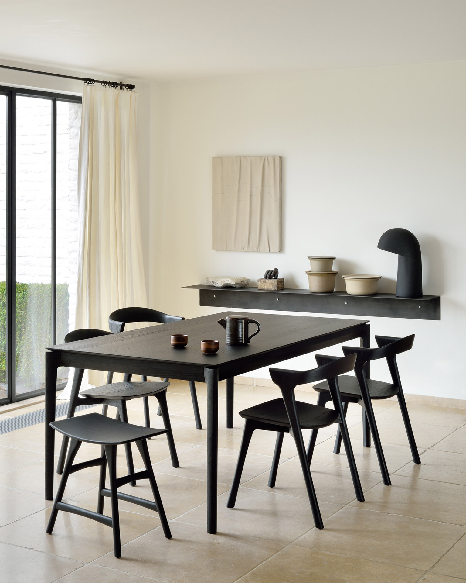 Schwarzer Esstisch mit Stühlen und Hockern aus Holz im minimalistischen Design für Esszimmer.