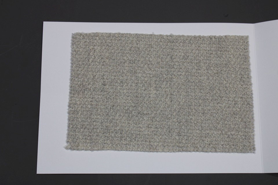 Stoffmusterkarte Gruppe 82 Cor: Nahaufnahme eines grauen, gewebten Möbelstoffs für Polster.