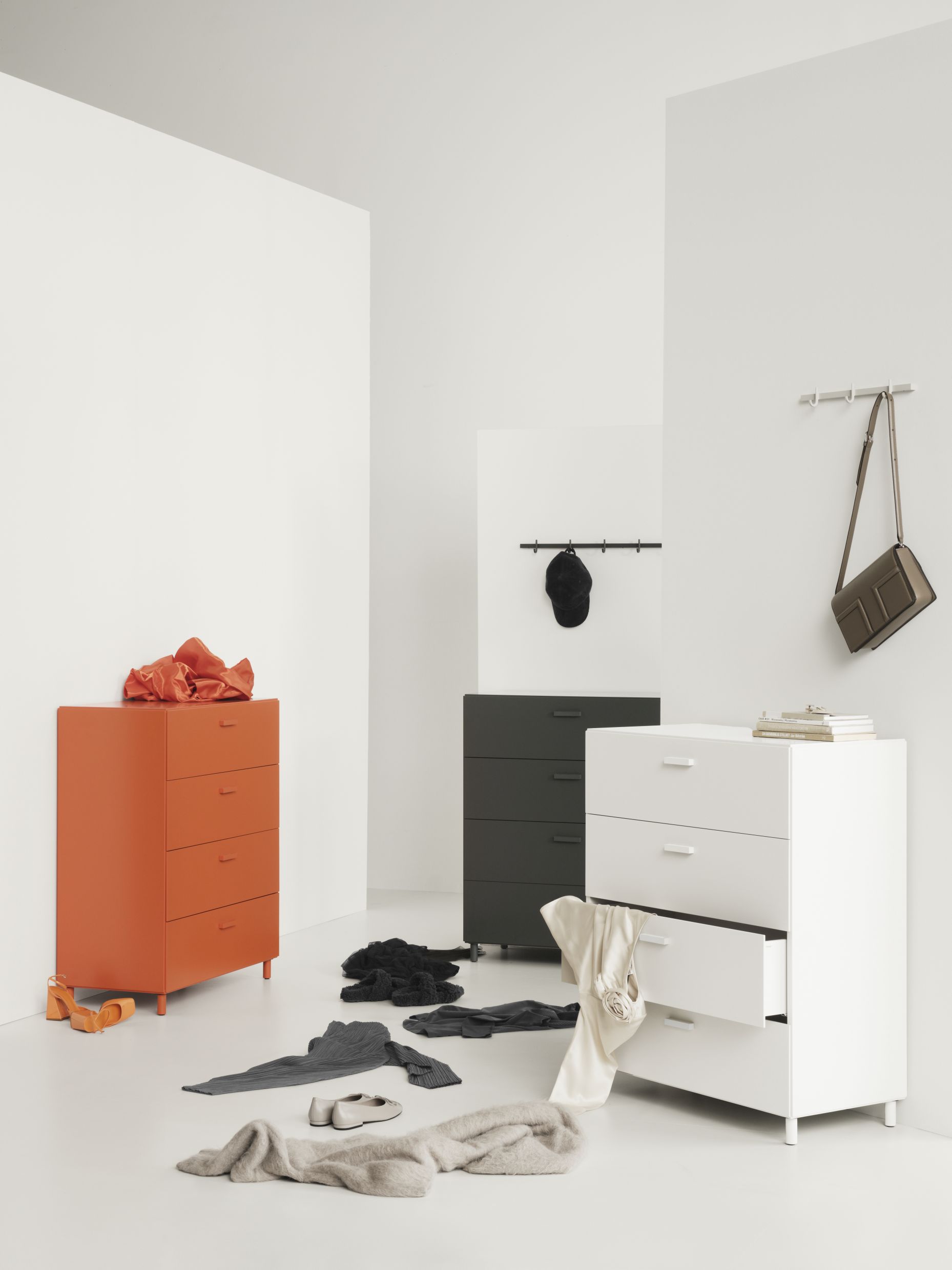 Orangefarbene Relief Kommode von String Furniture mit vier Schubladen und hellen Holzbeinen.