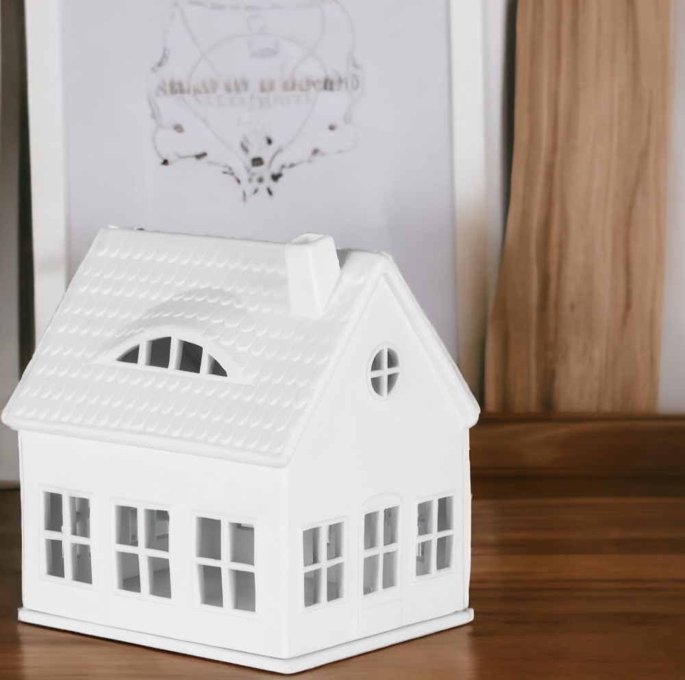 Weißes Lichthaus im Gaubenhaus-Stil von Räder, dekoratives Keramikhaus mit Fenstern und Schornstein.