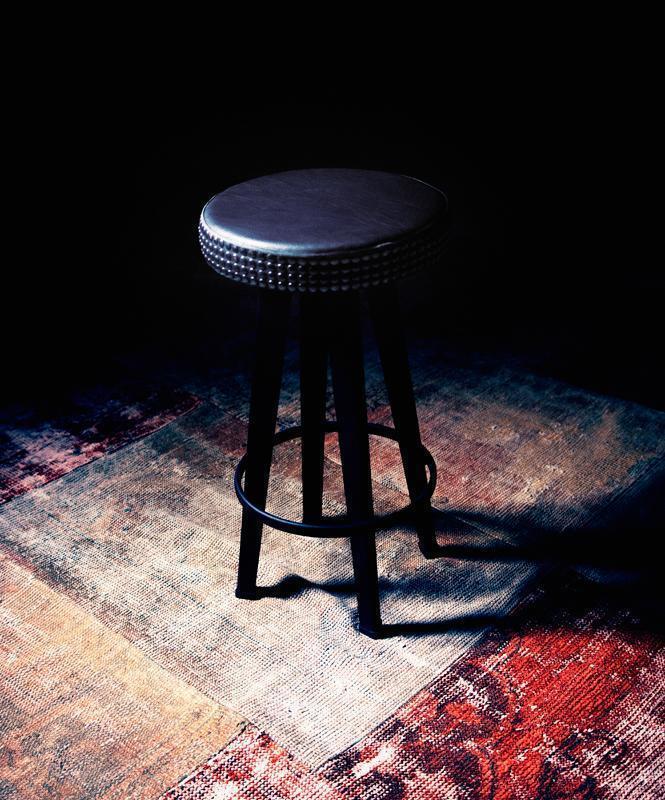 Schwarzer Bar Stud Barhocker von Moroso Diesel mit Nieten auf einem gemusterten Teppich.